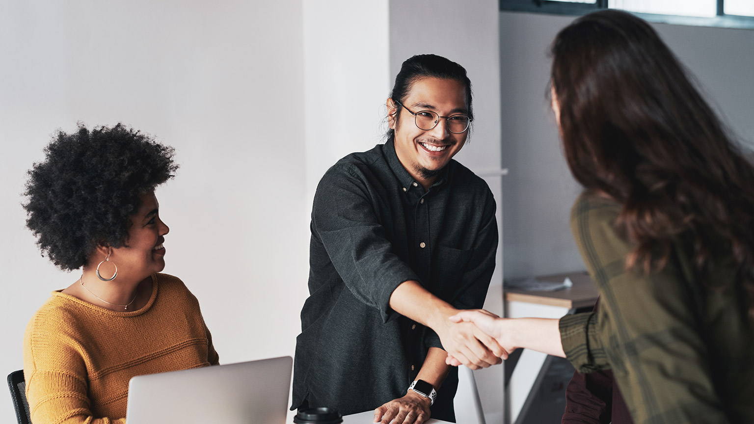 A group of business people shaking hands after completing a deal