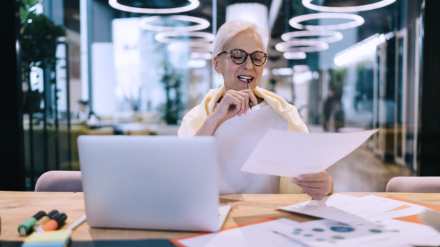 Busy matured woman working on project with laptop