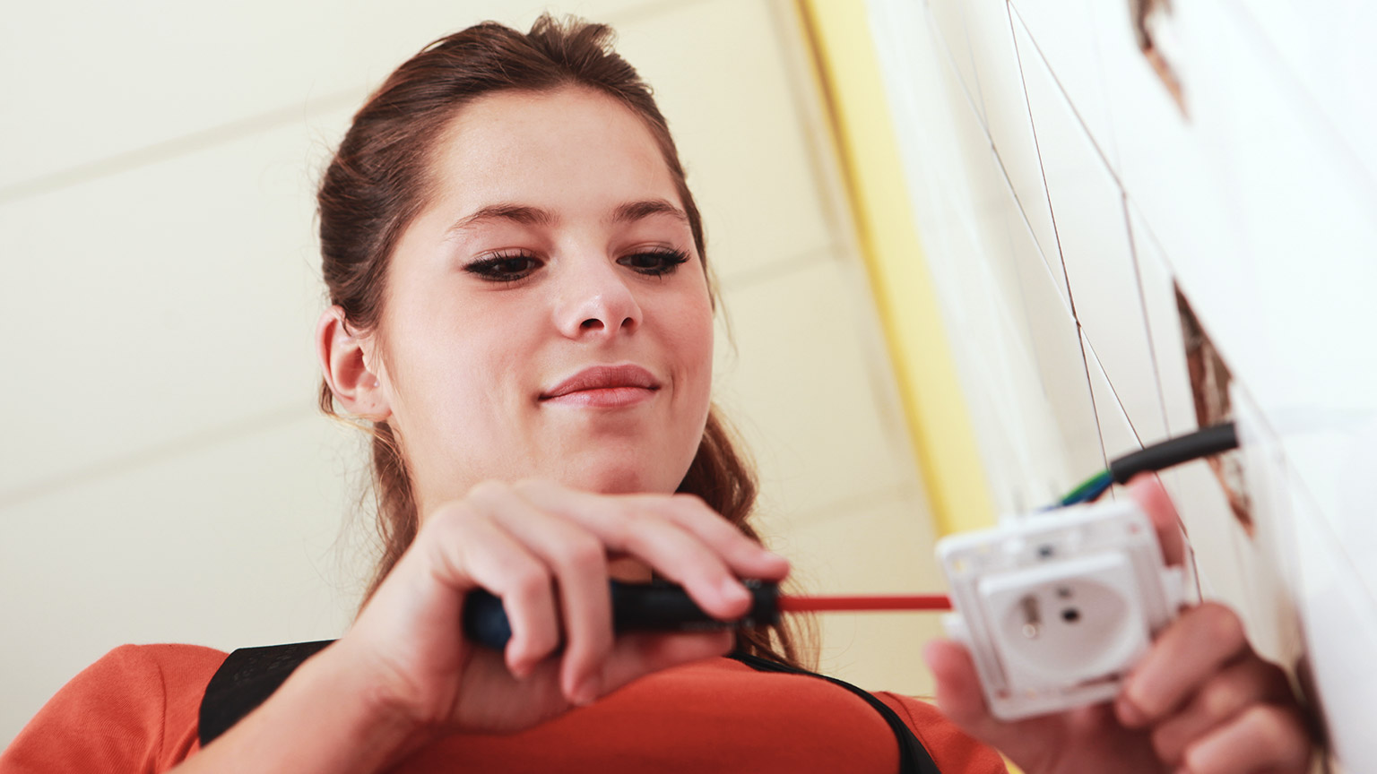 An electrical apprentice working on wiring something up