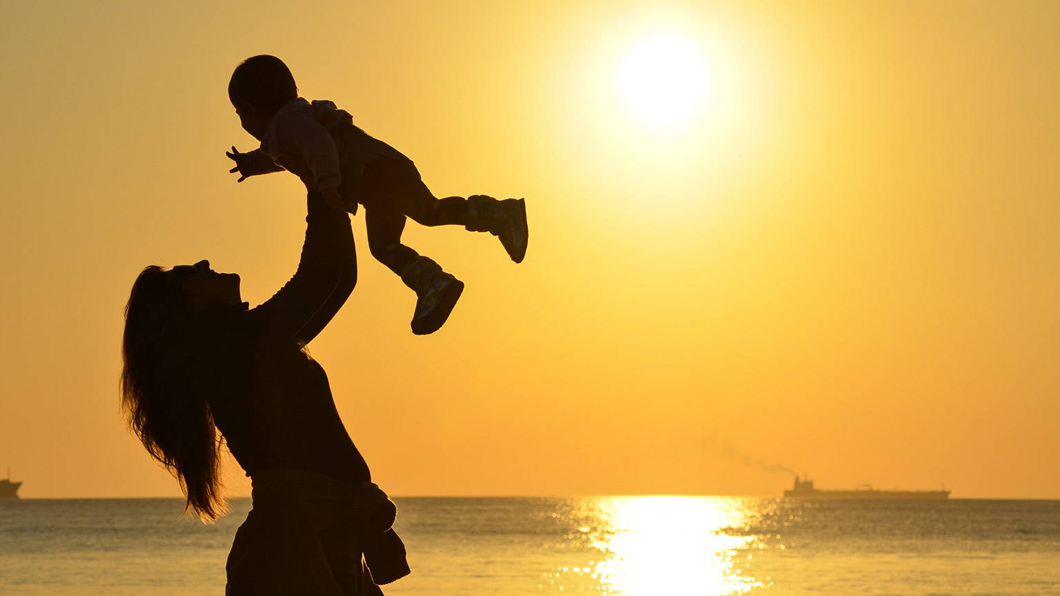 A mother lifting her child in the air