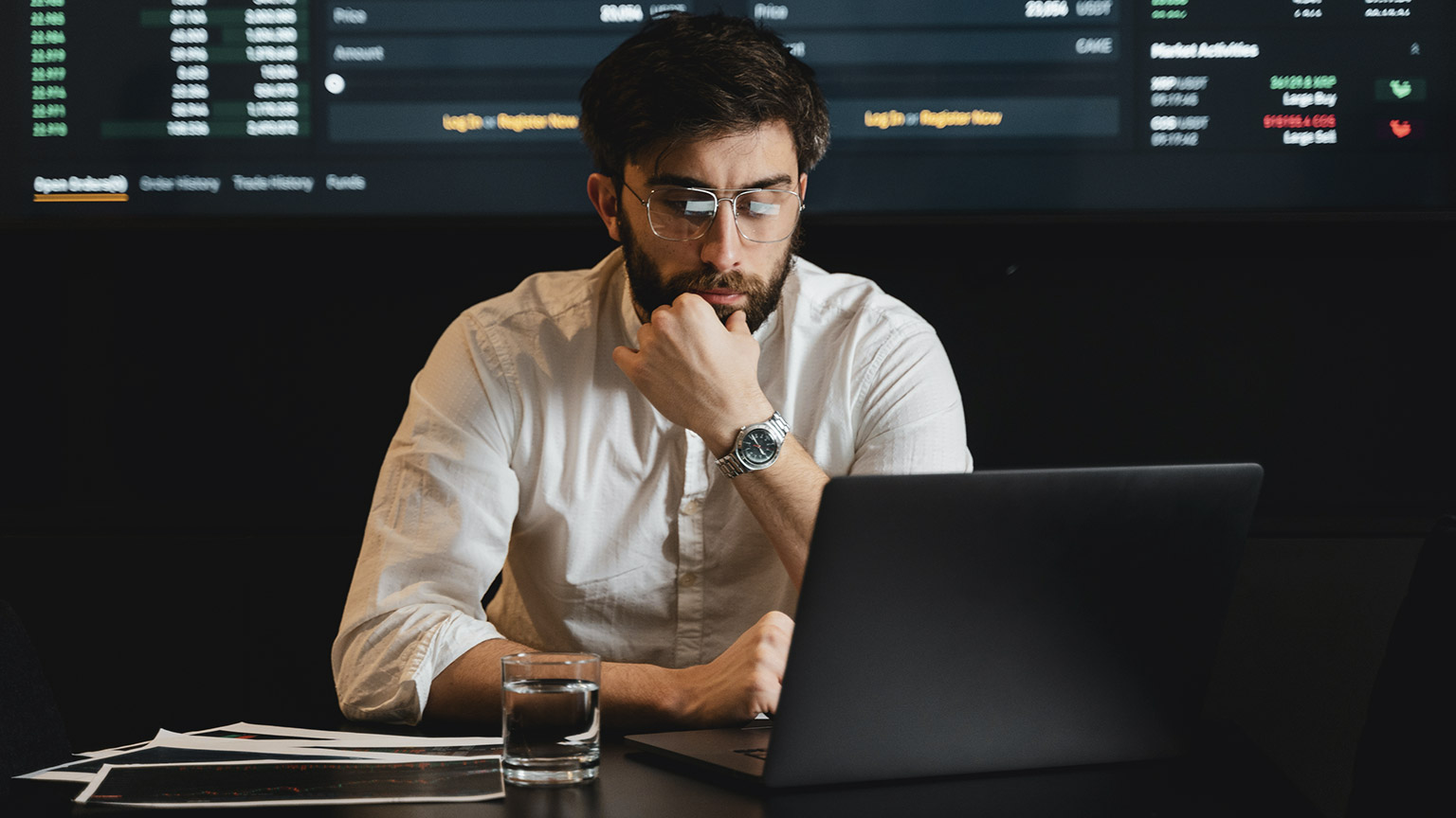 A data analyst sitting in a room crunching numbers on a laptop