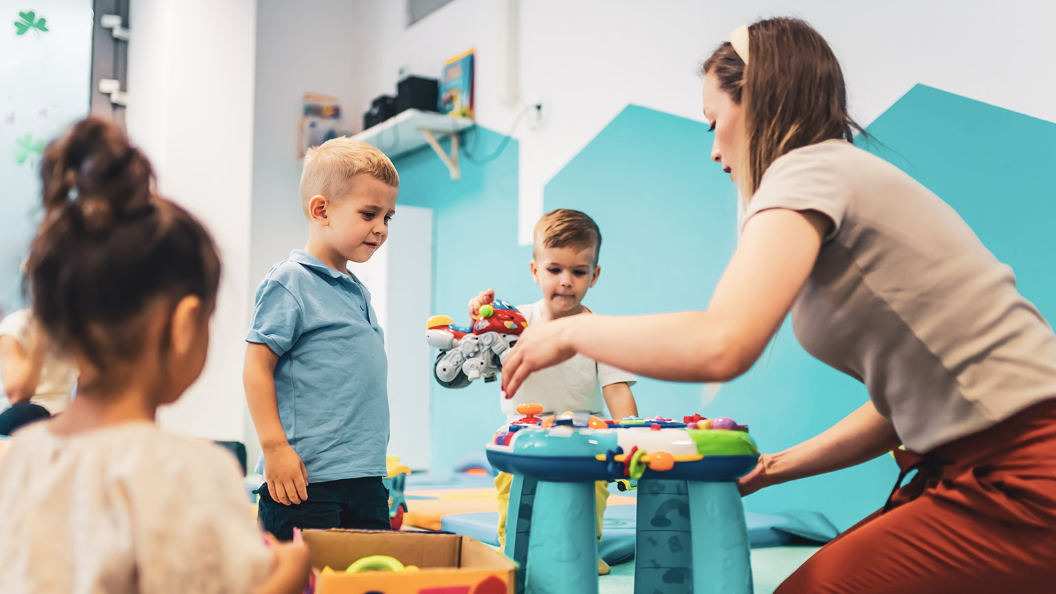 A childcare worker with a group of kids in a centre