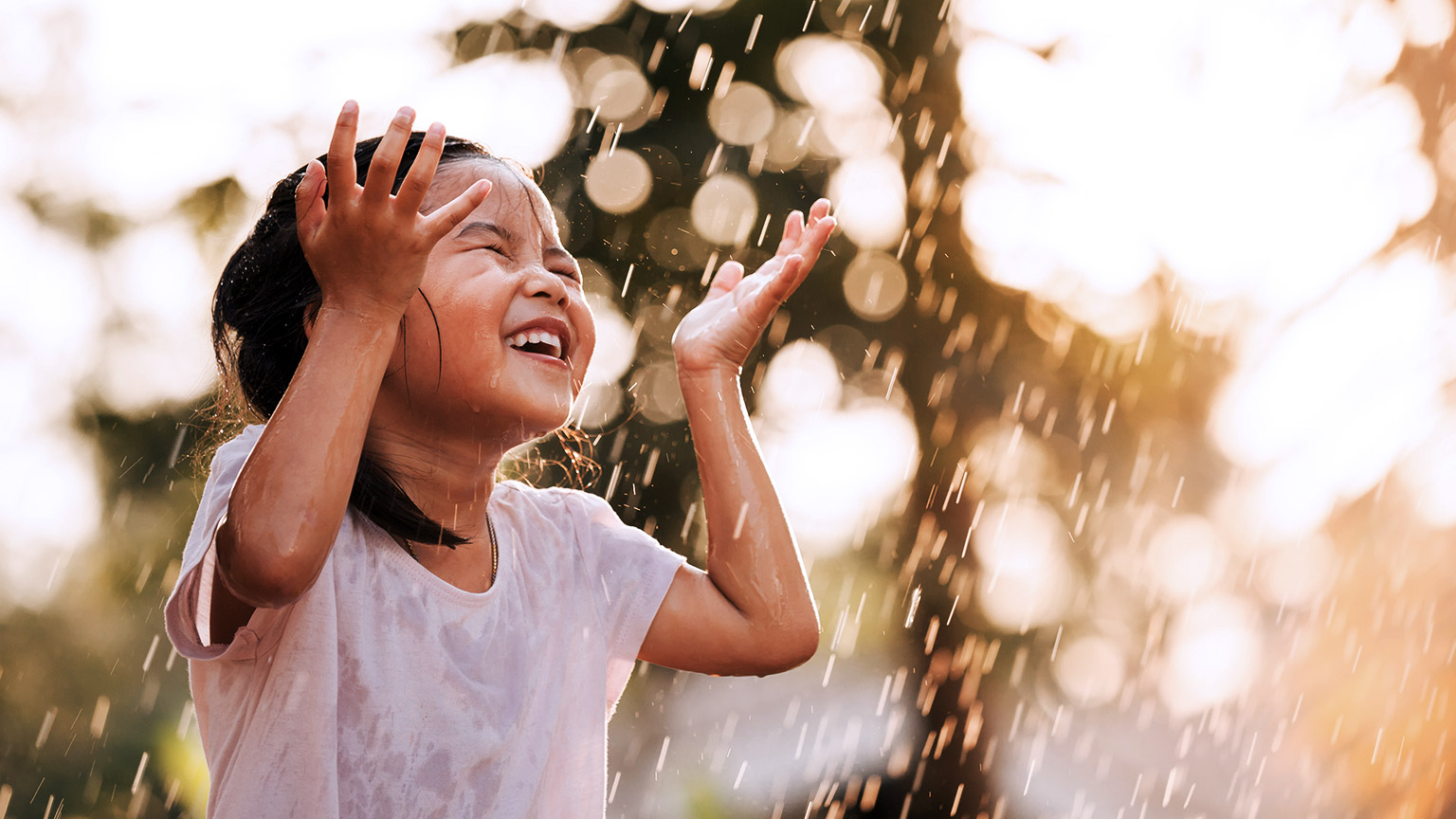 Happy child playing in the rain