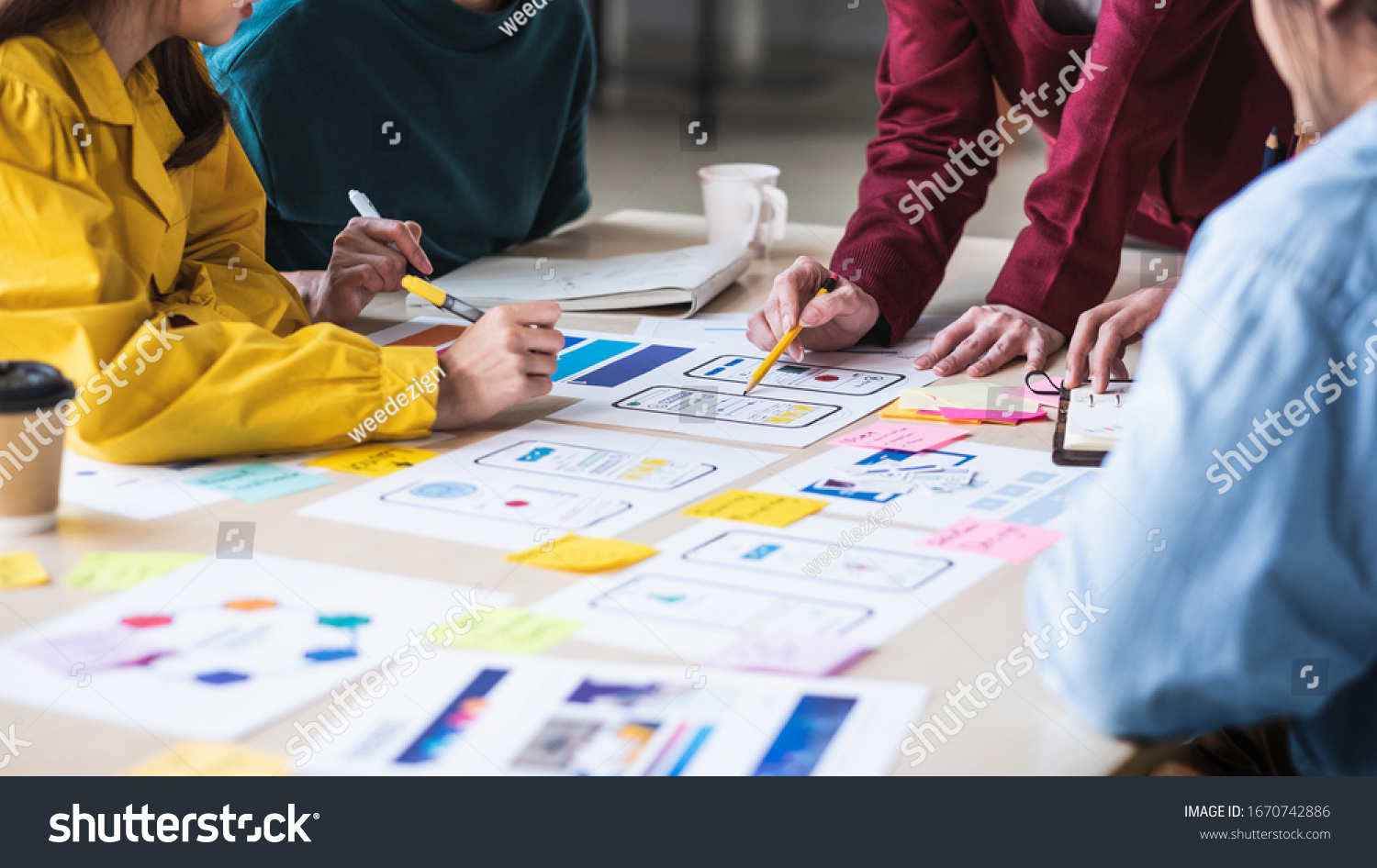 Close up ux developer and ui designer brainstorming about mobile app interface wireframe design 