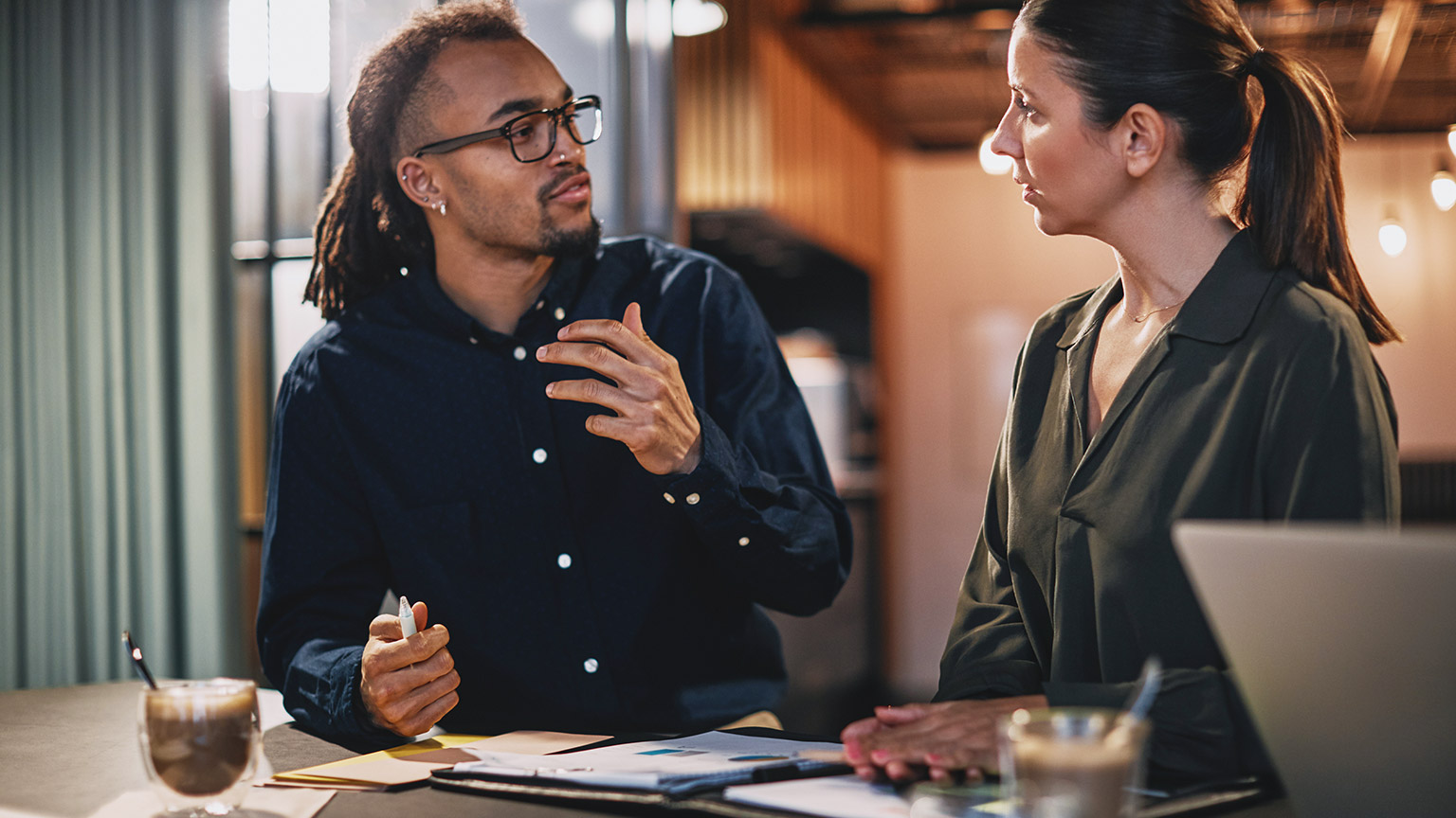 2 colleagues discussing work in a modern office space