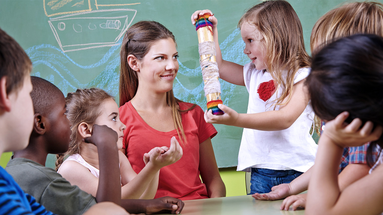 Kindergarten students playing rainmaker instrument