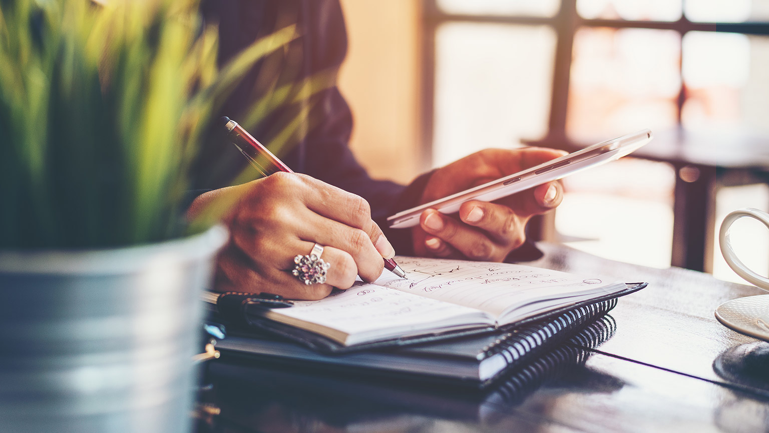 A close view of a person writing notes on a pad