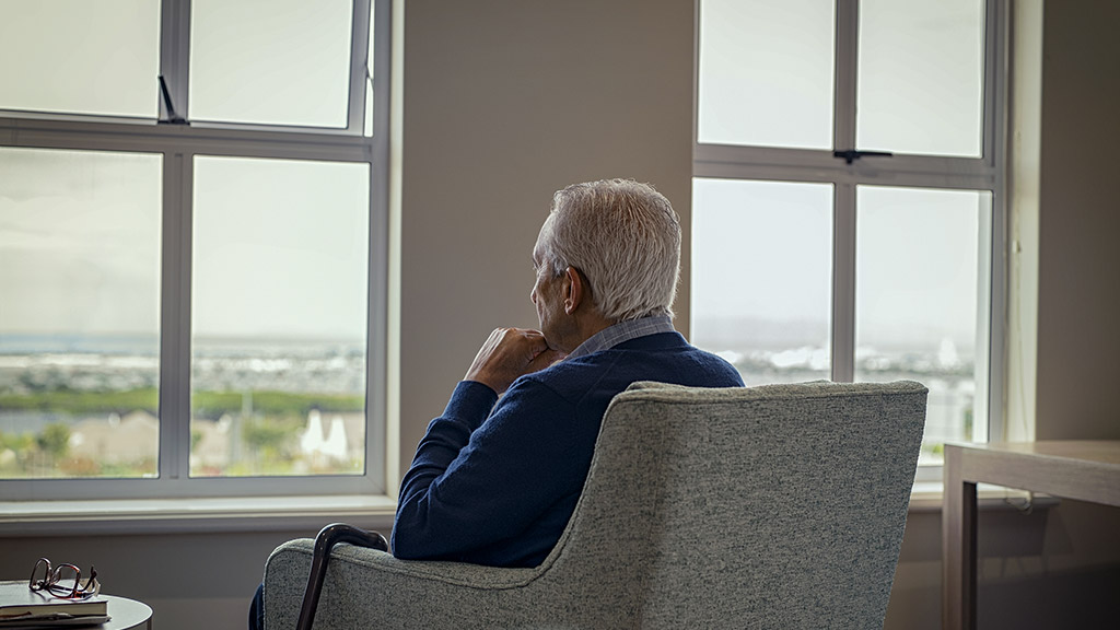 an elder man thinking while sitting on a couch