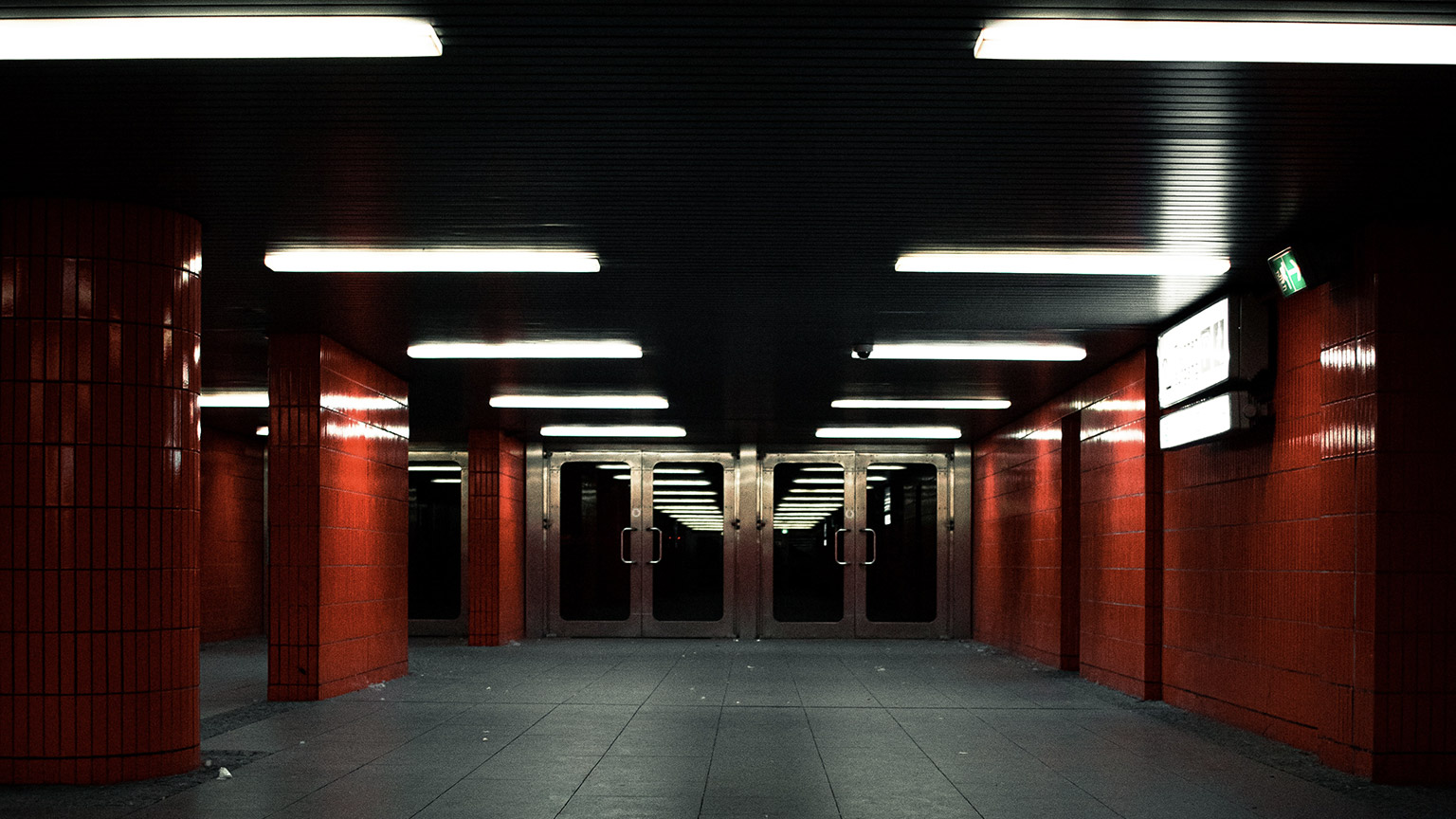 A train station lit by overhead flourescent lights