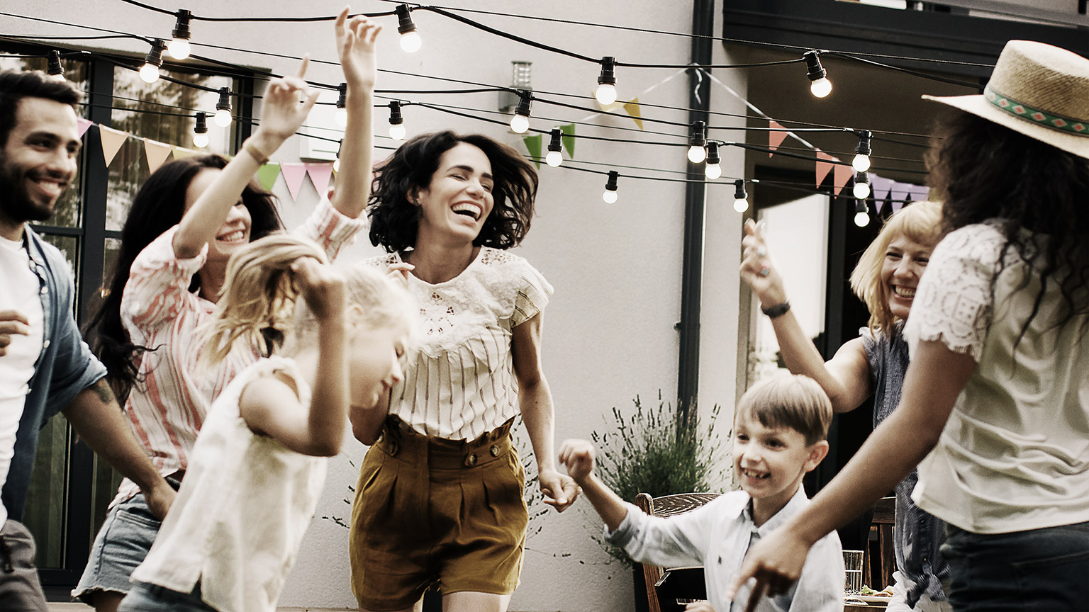 A happy family dancing together with children