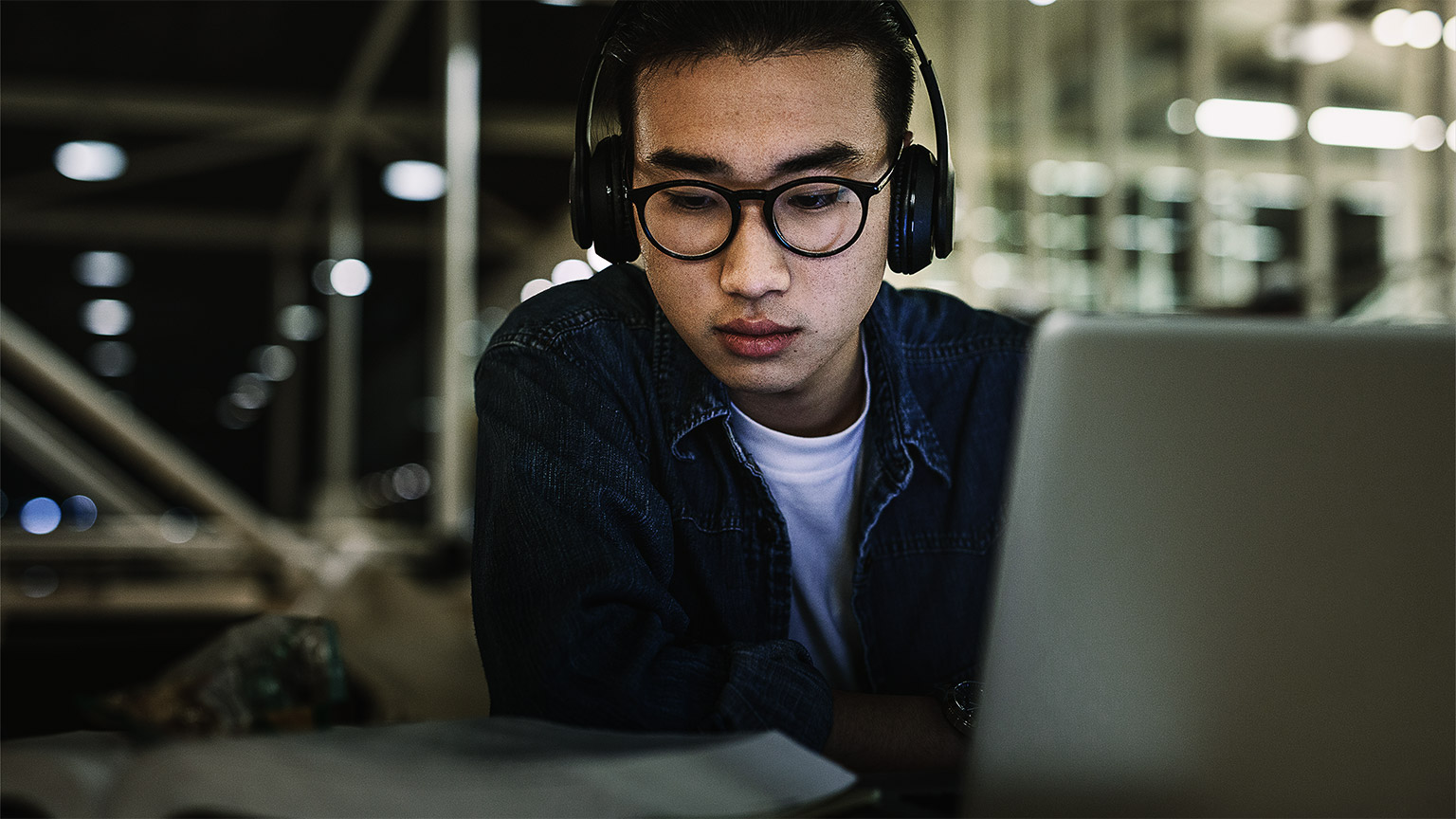 A student studying with a laptop and a book