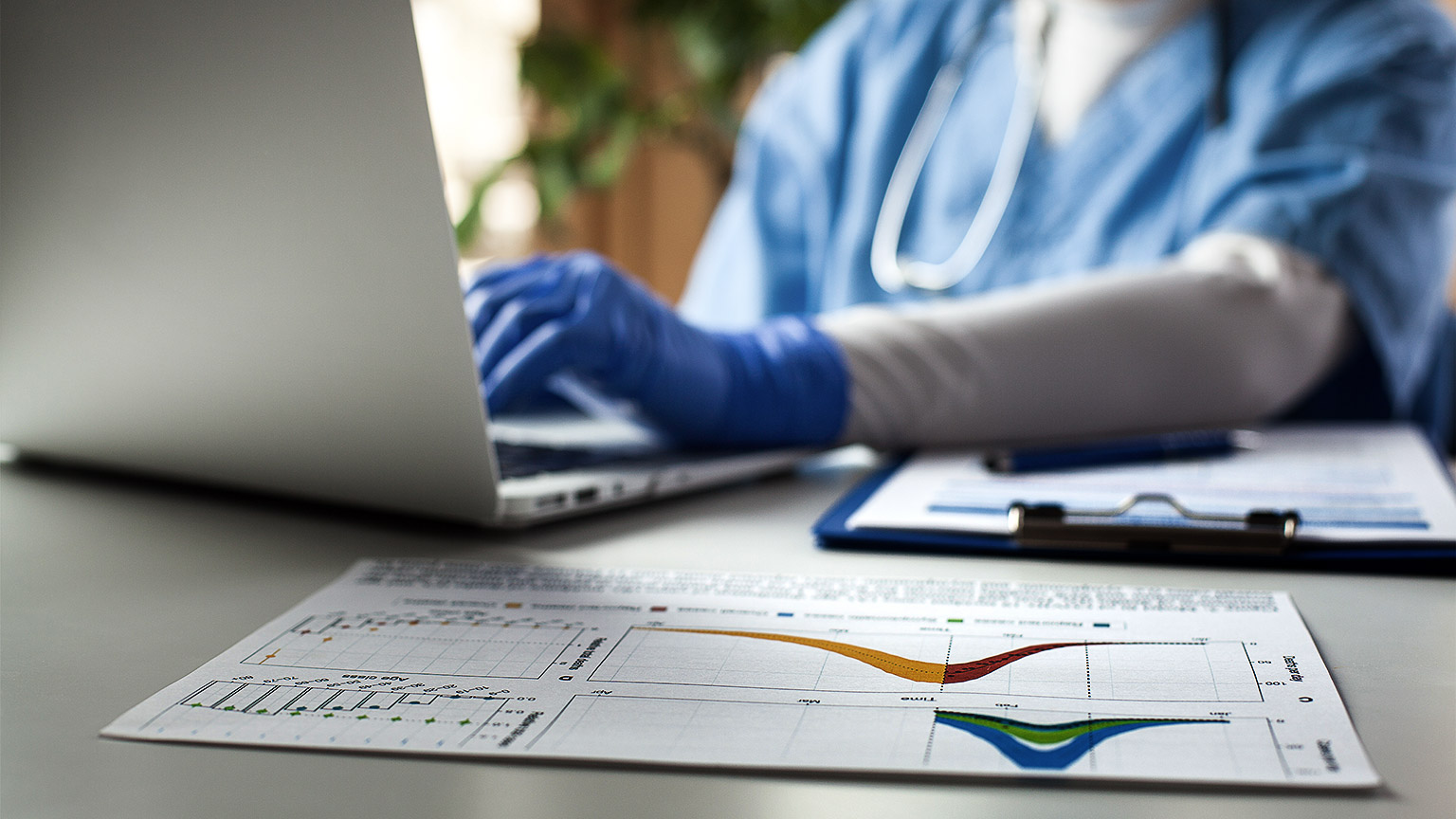 Epidemiologist doctor working on laptop computer,analyzing graphs charts