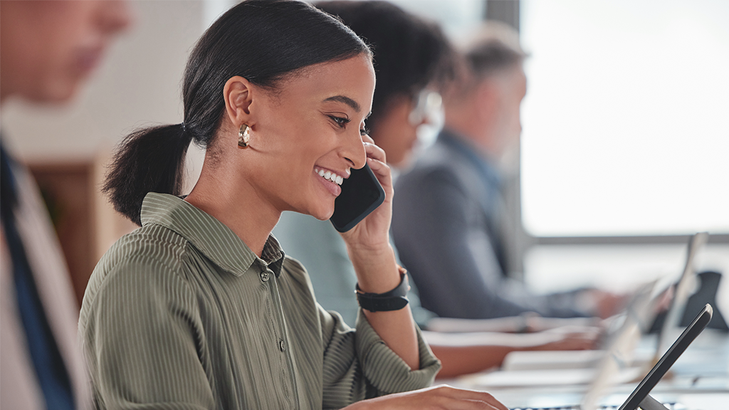  young businesswoman talking on a cellphone while working on a digital tablet