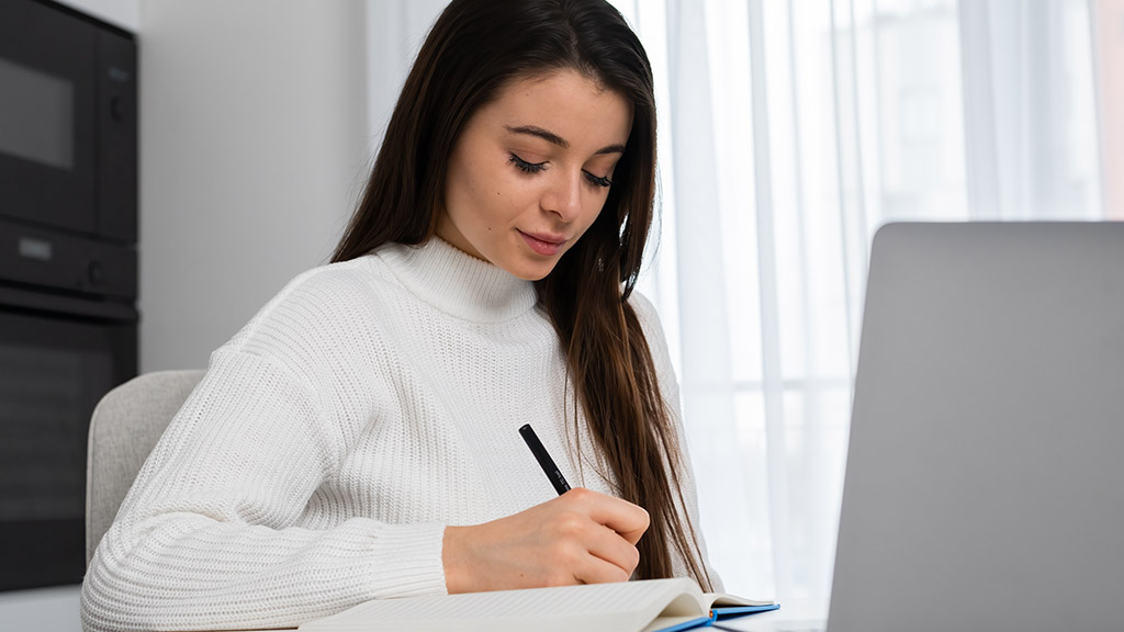 writing notes to textbook sitting at home