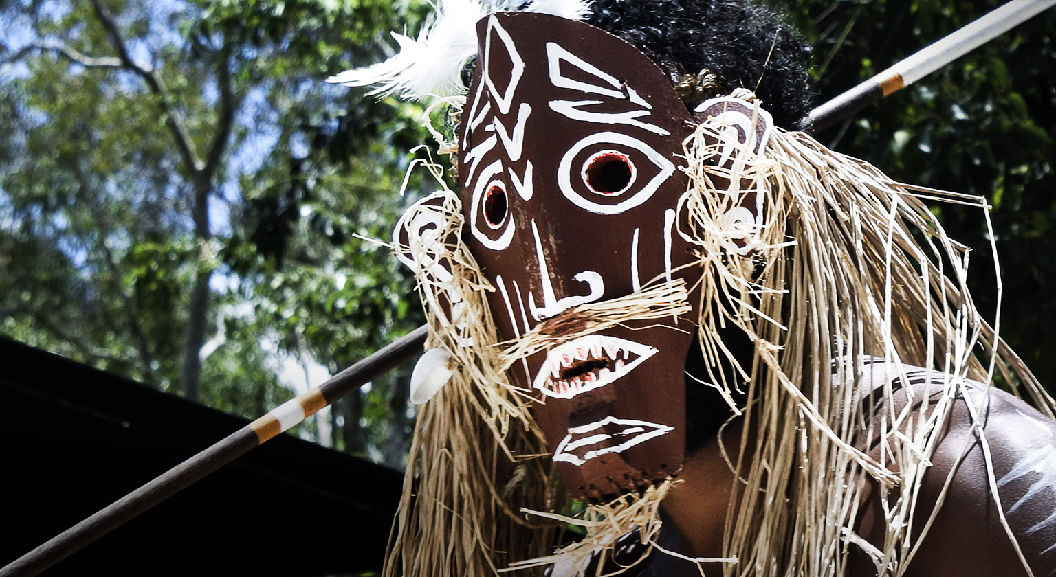 Indigenous Australian Torres Strait Islander warrior man wearing a traditional mask dancing in a culture event ceremony in a village in Torres Strait Island near Cape York, Queensland, Australia.