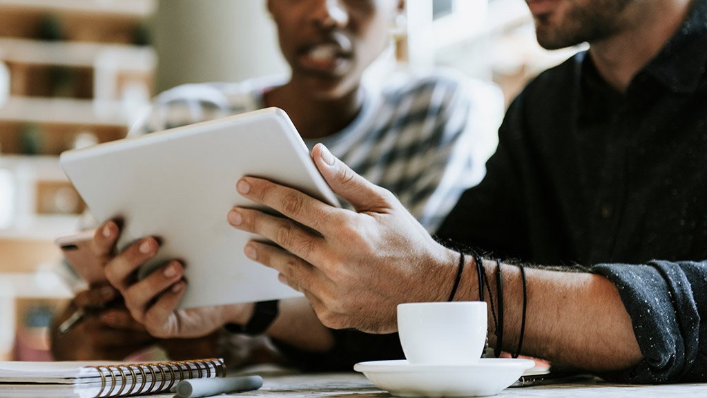 Colleagues discussing their work on a tablet