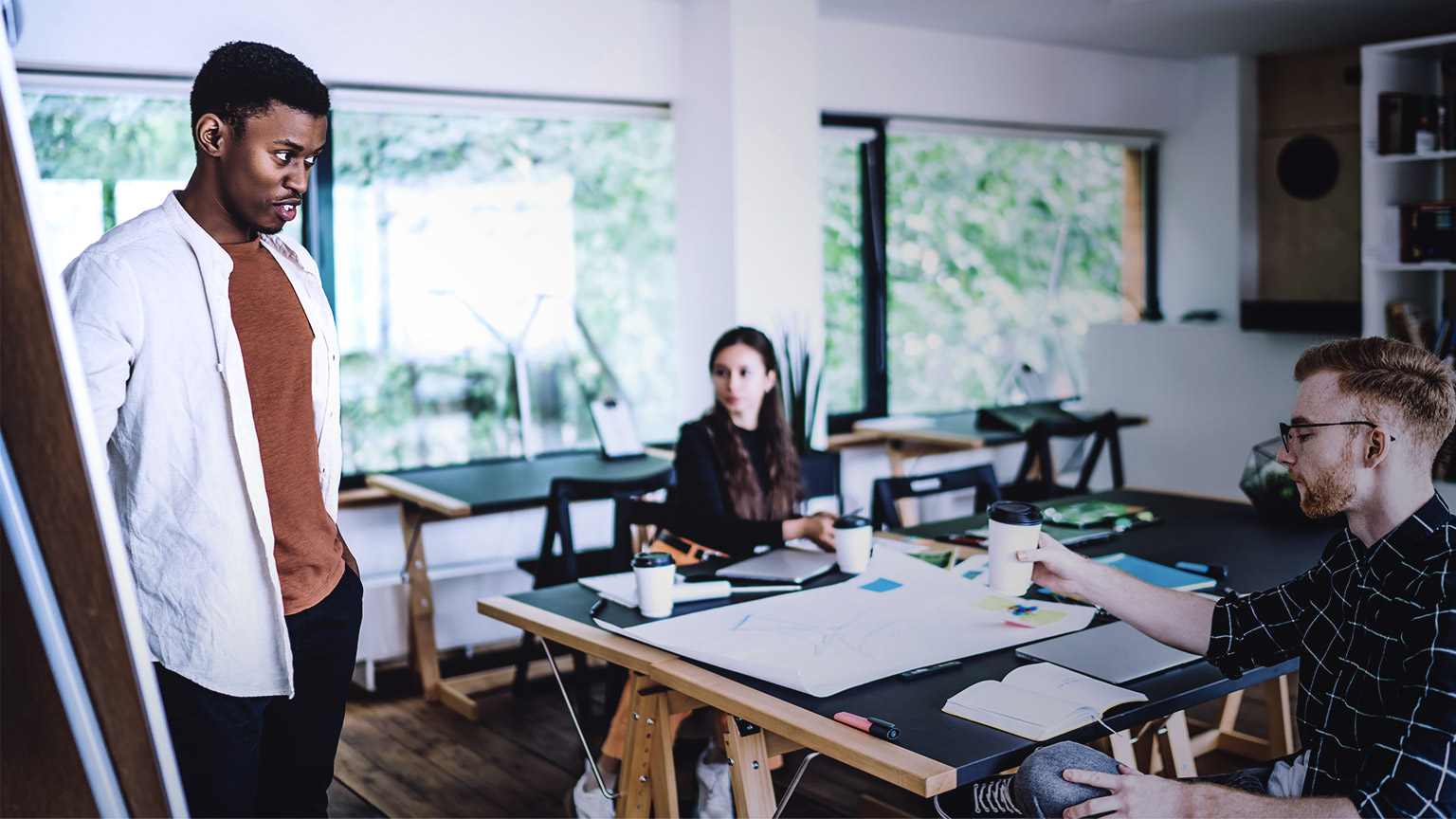 Man coaching two officemates