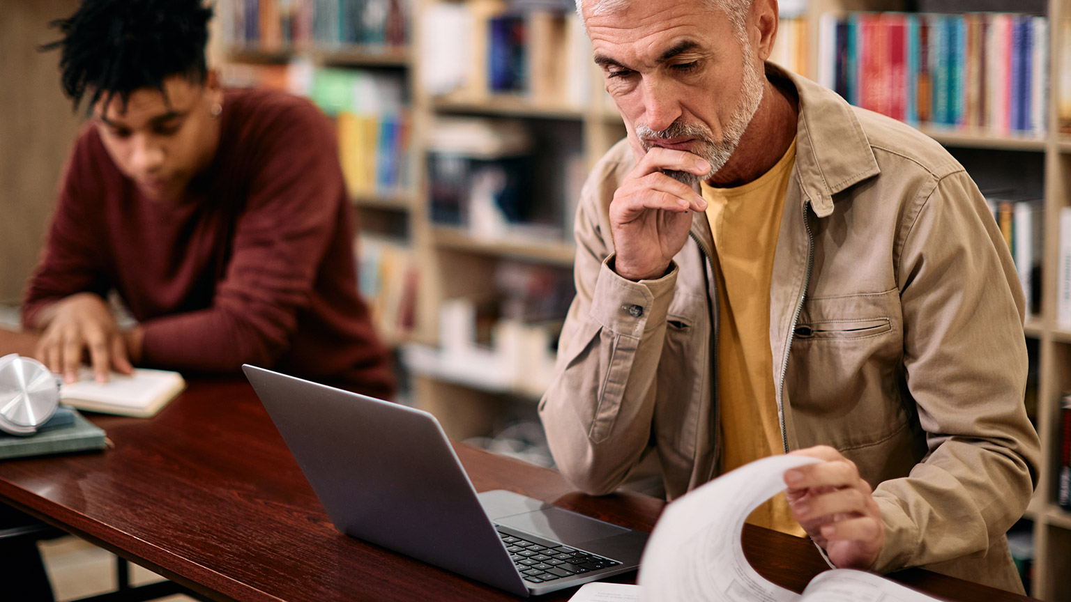 2 people reading information in a library