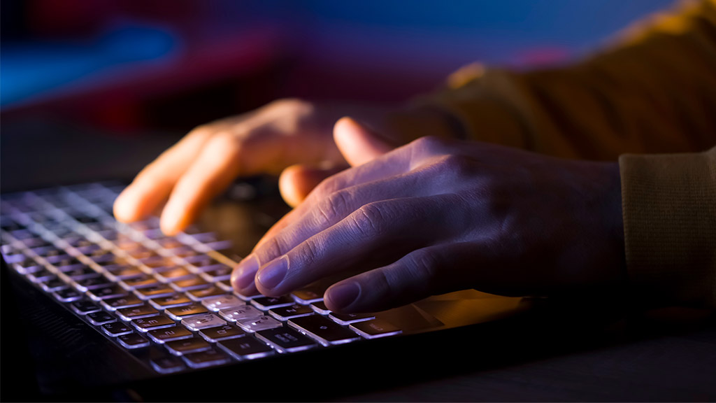 Male hands are typing on a laptop keyboard