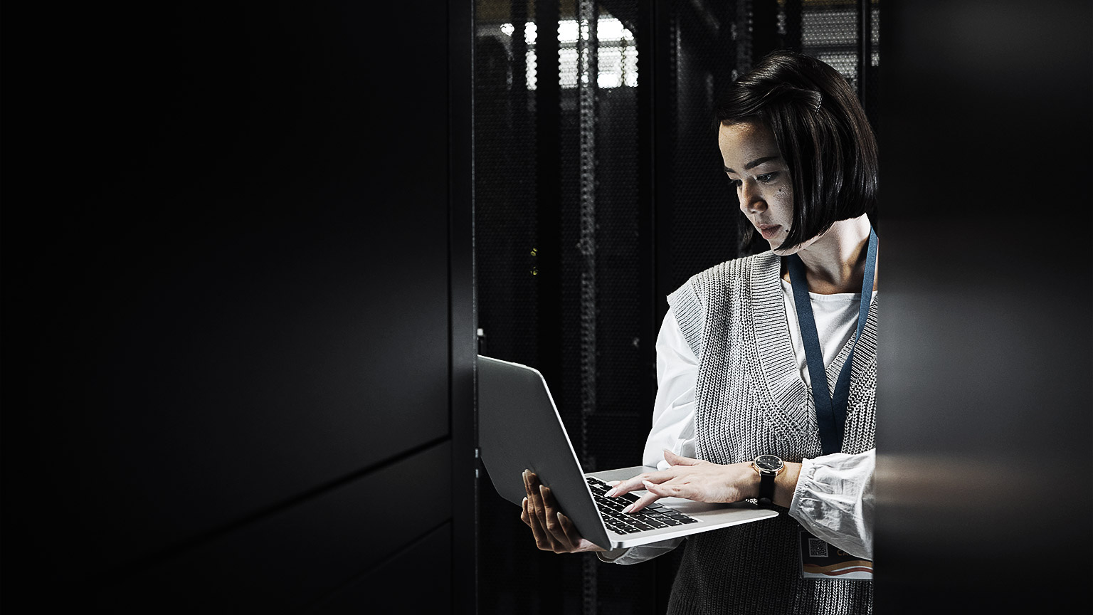 A person holding a laptop in a data center