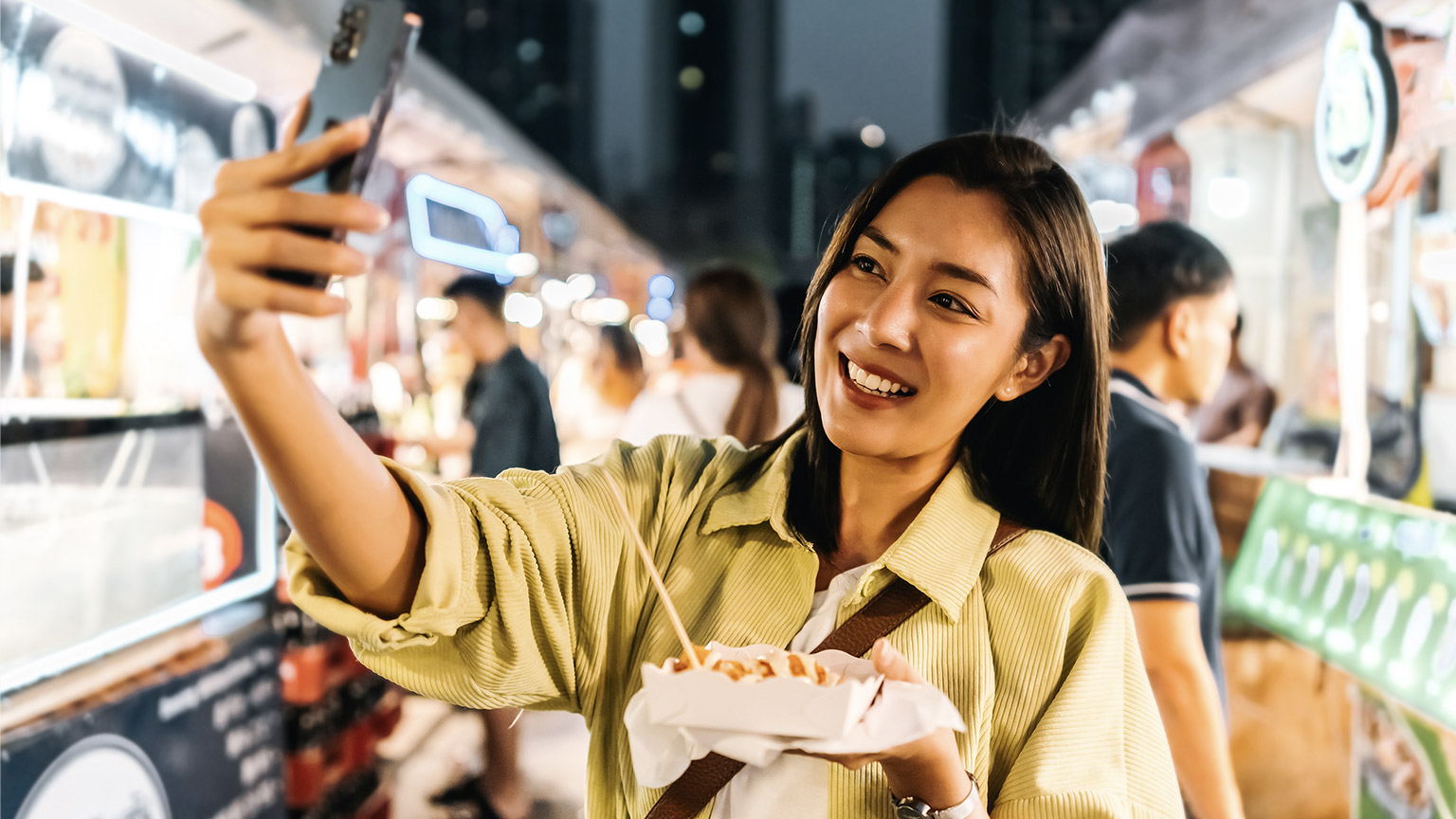 Woman taking selfie with street food