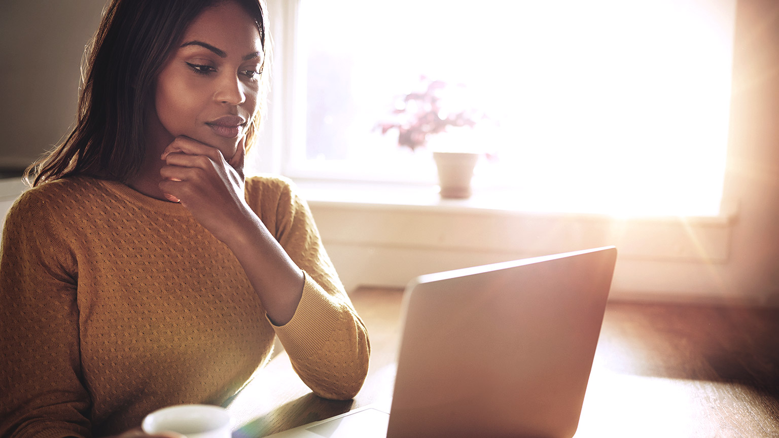 Dark skinned woman looking at the computer