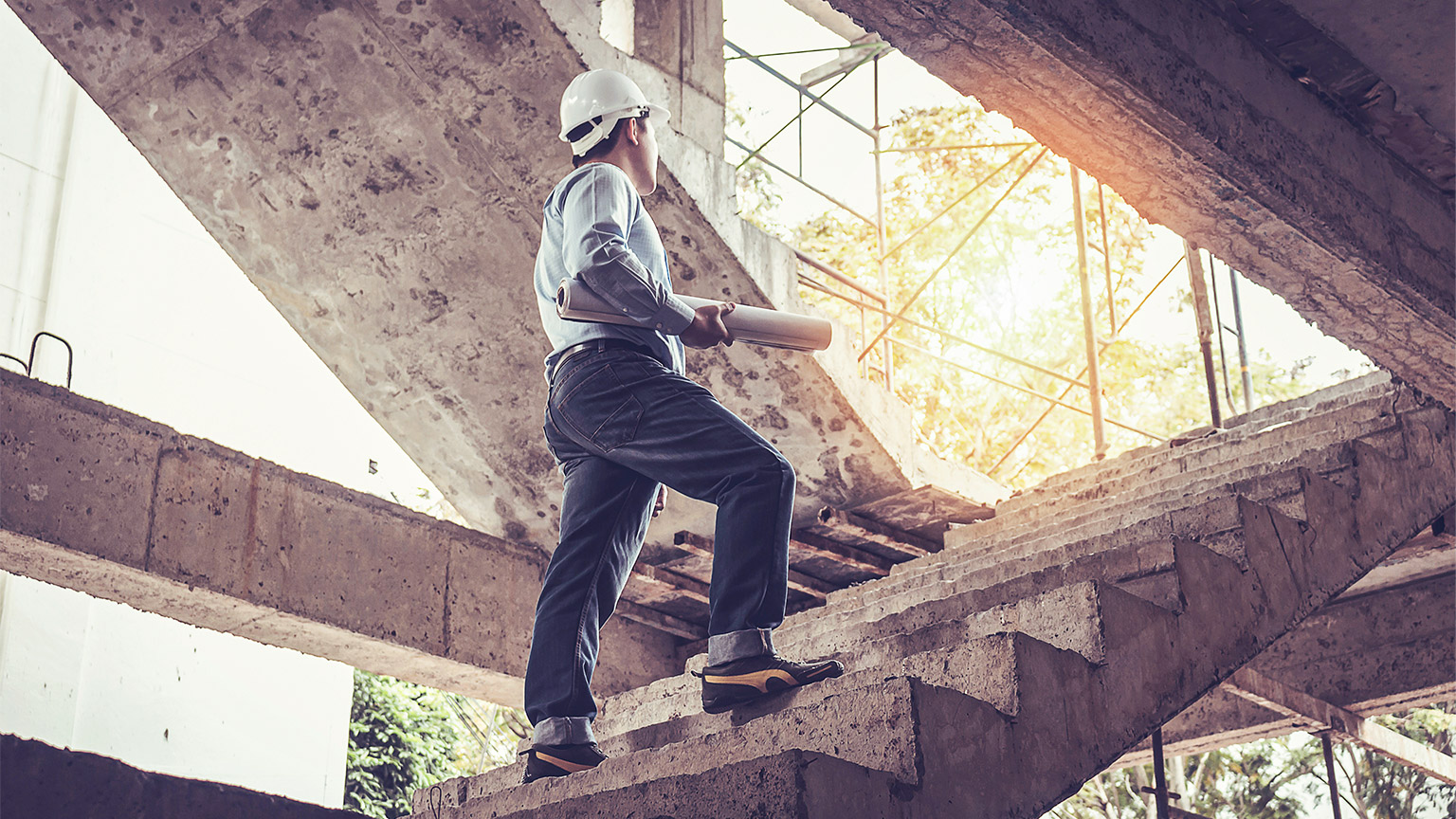 Man walking up a flight of stairs at a building site