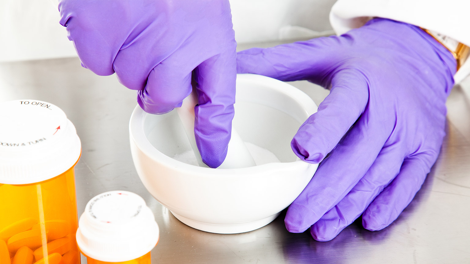 A pharmacist crushing tablets