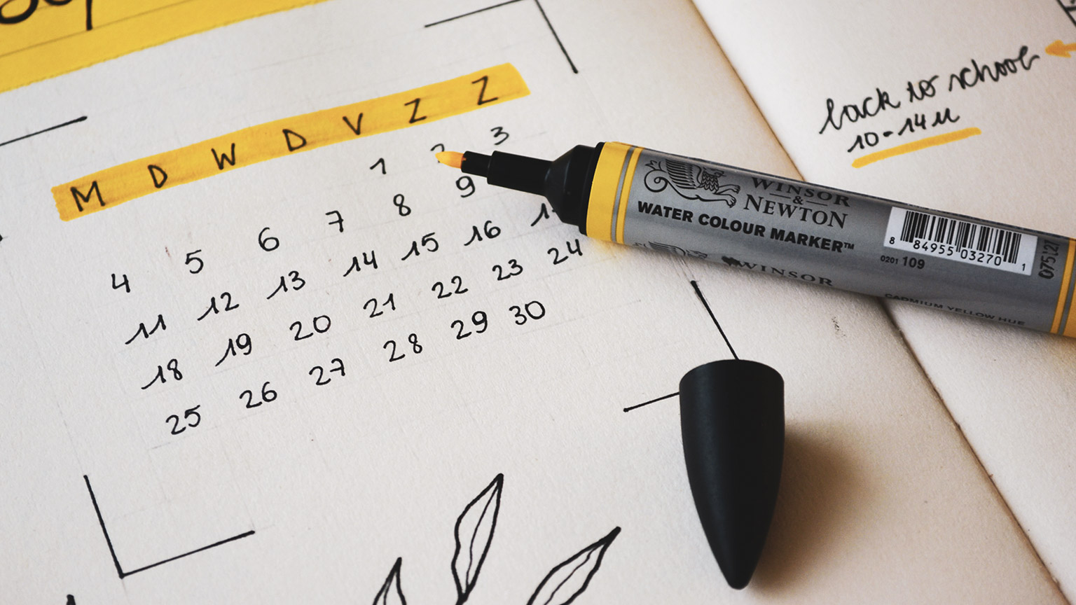 A calendar and pen on a table