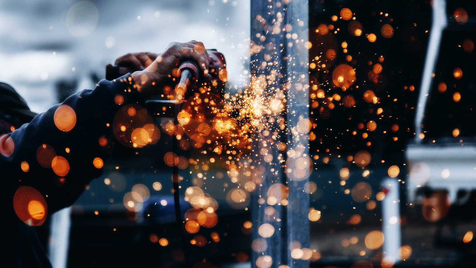 Person working in construction with hot embers flying off