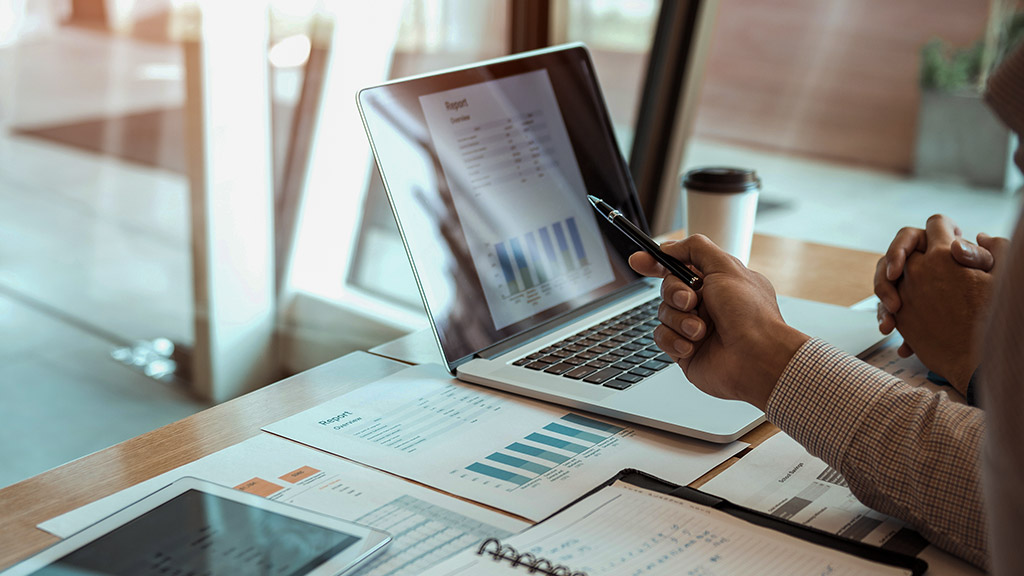 Manager is using a laptop computer while analyzing the company's financial statements