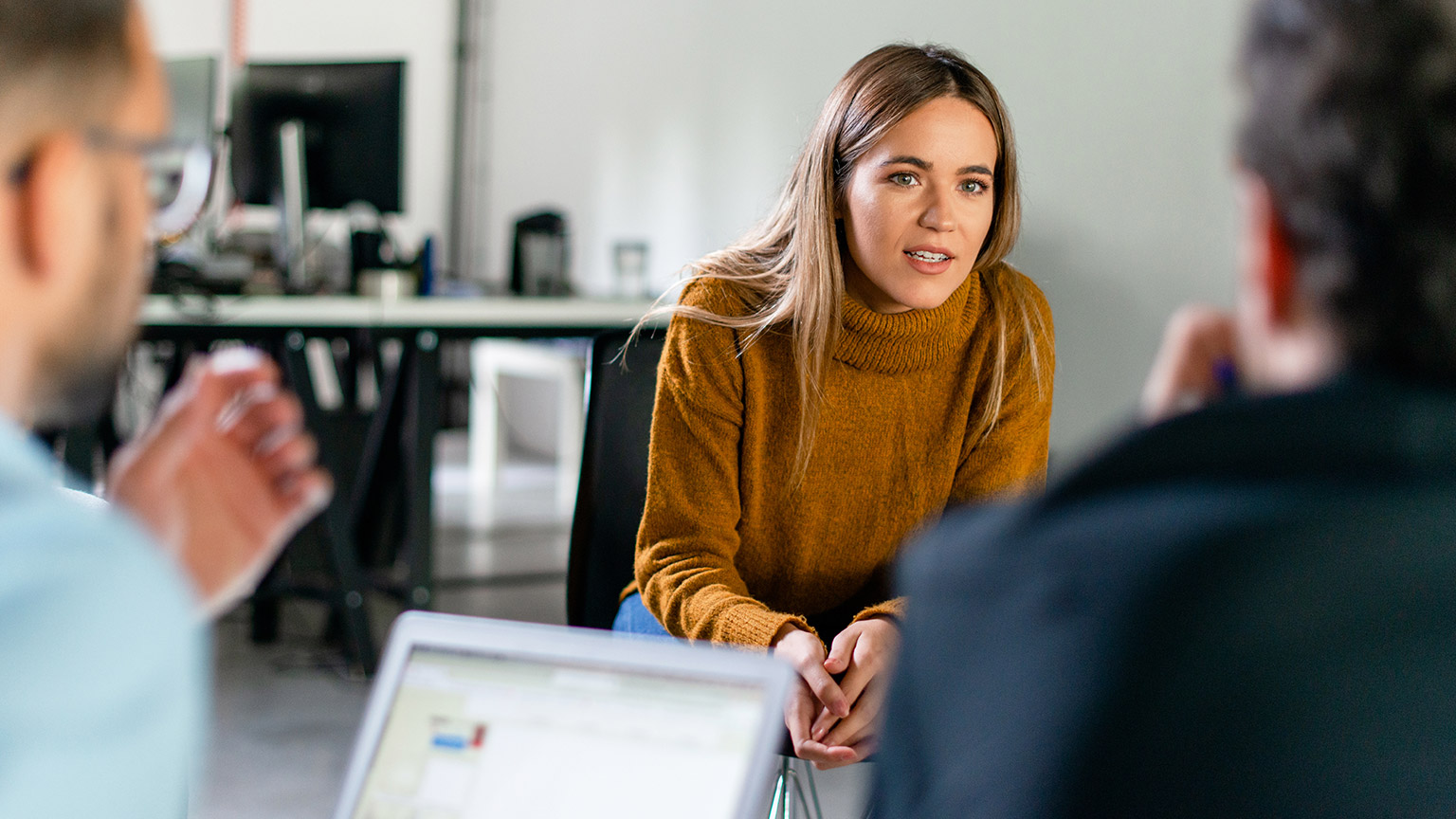 A group of people discussing work in an office