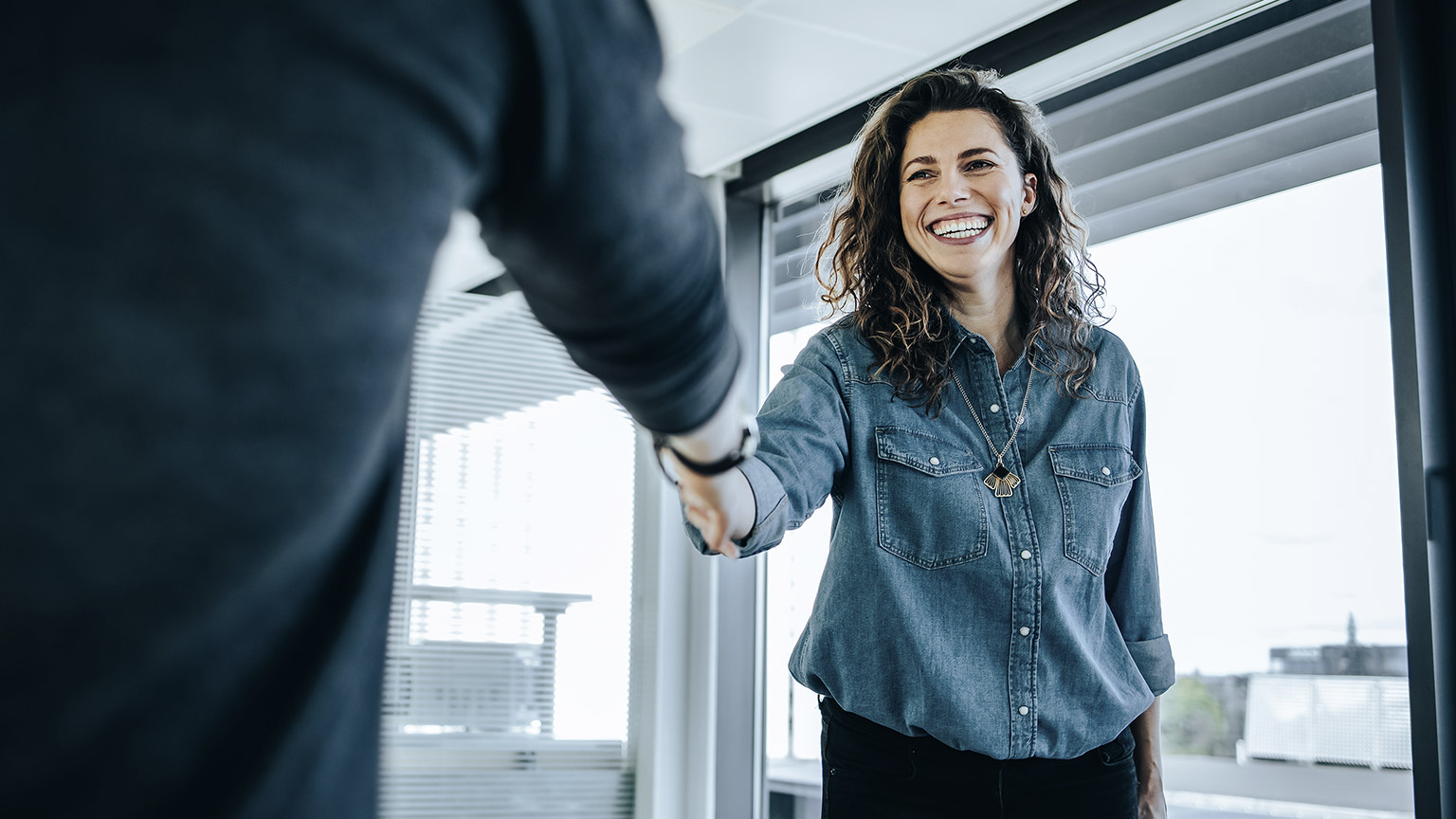 Businessman shaking hands with smiling woman