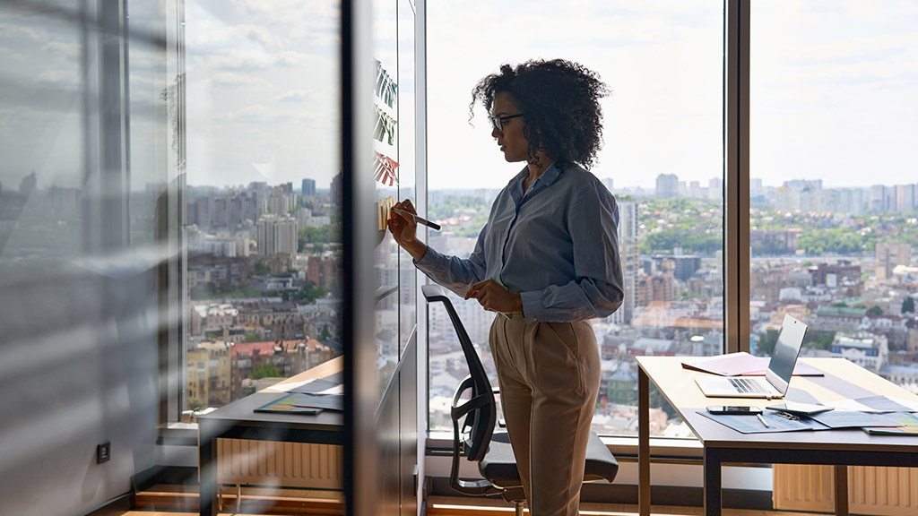 Young African american executive manager businesswoman writing strategy ideas on sticky notes