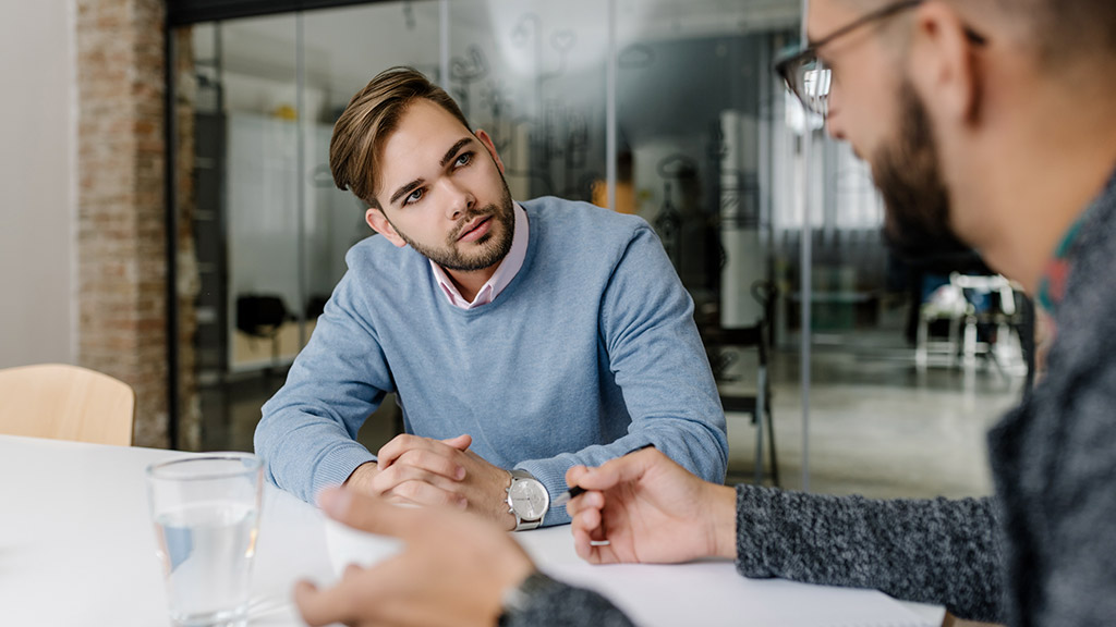 a man carefully listening to colleague