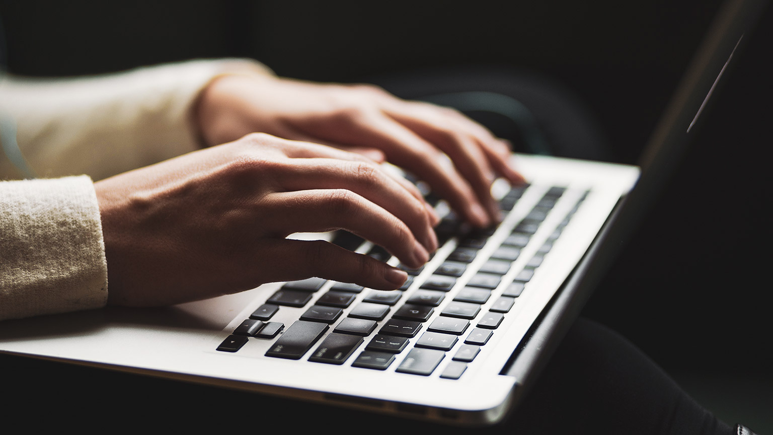 A person typing a laptop