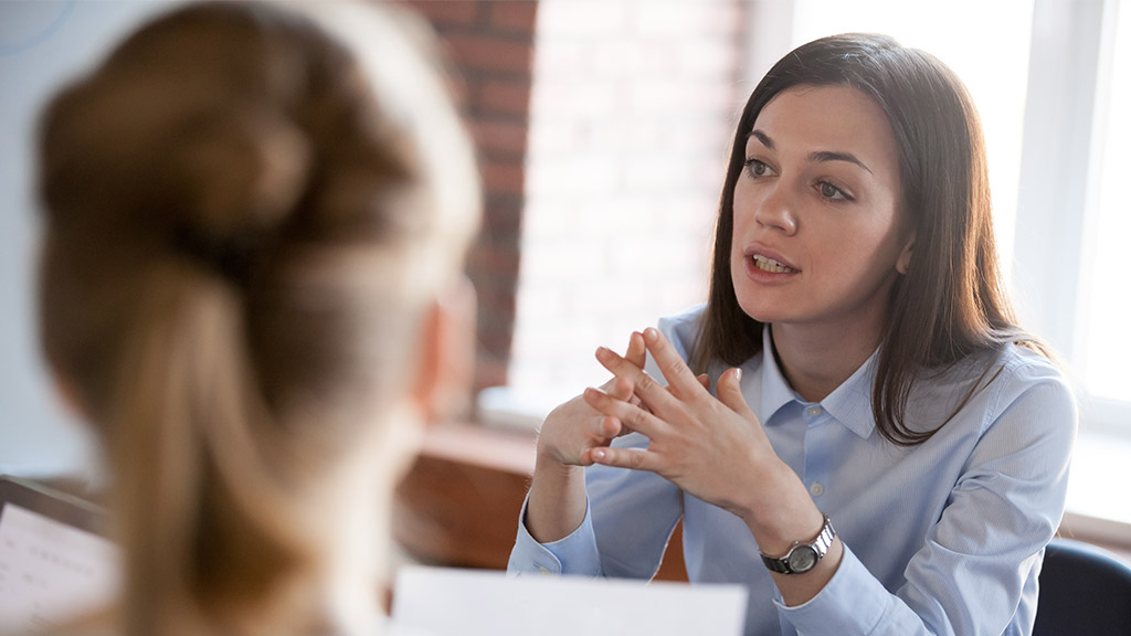 Confident focused businesswoman, teacher or mentor coach speaking to business people at negotiations