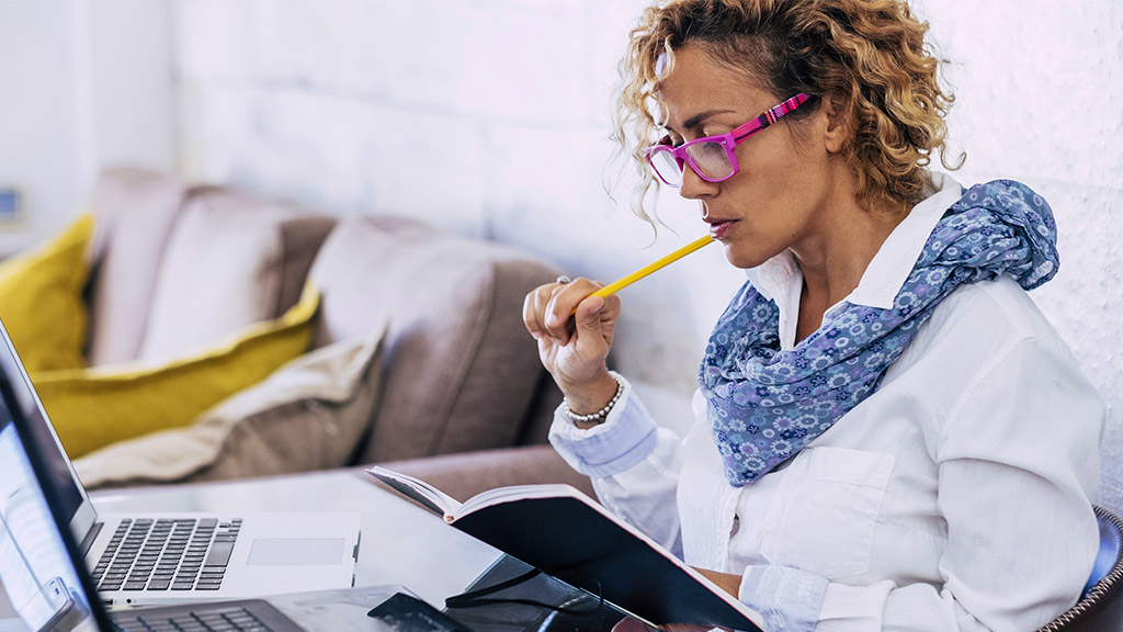 woman at home working with modern technology laptop and on paper