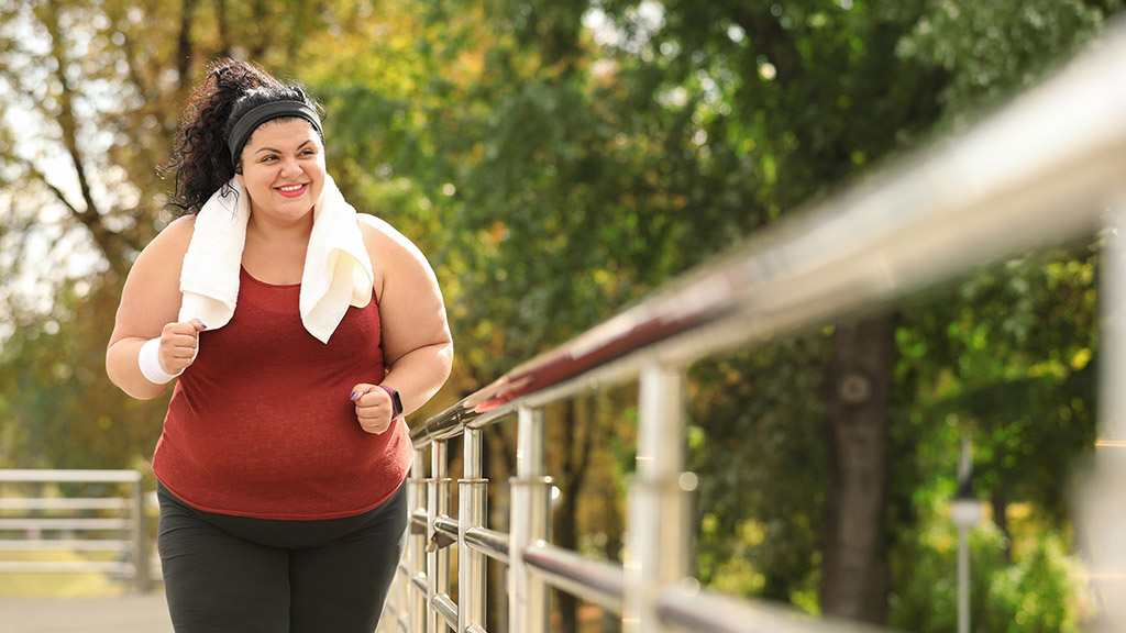 Beautiful overweight woman running outdoors