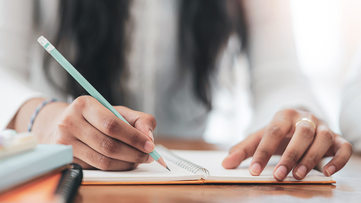 A close view of a person writing on a notepad