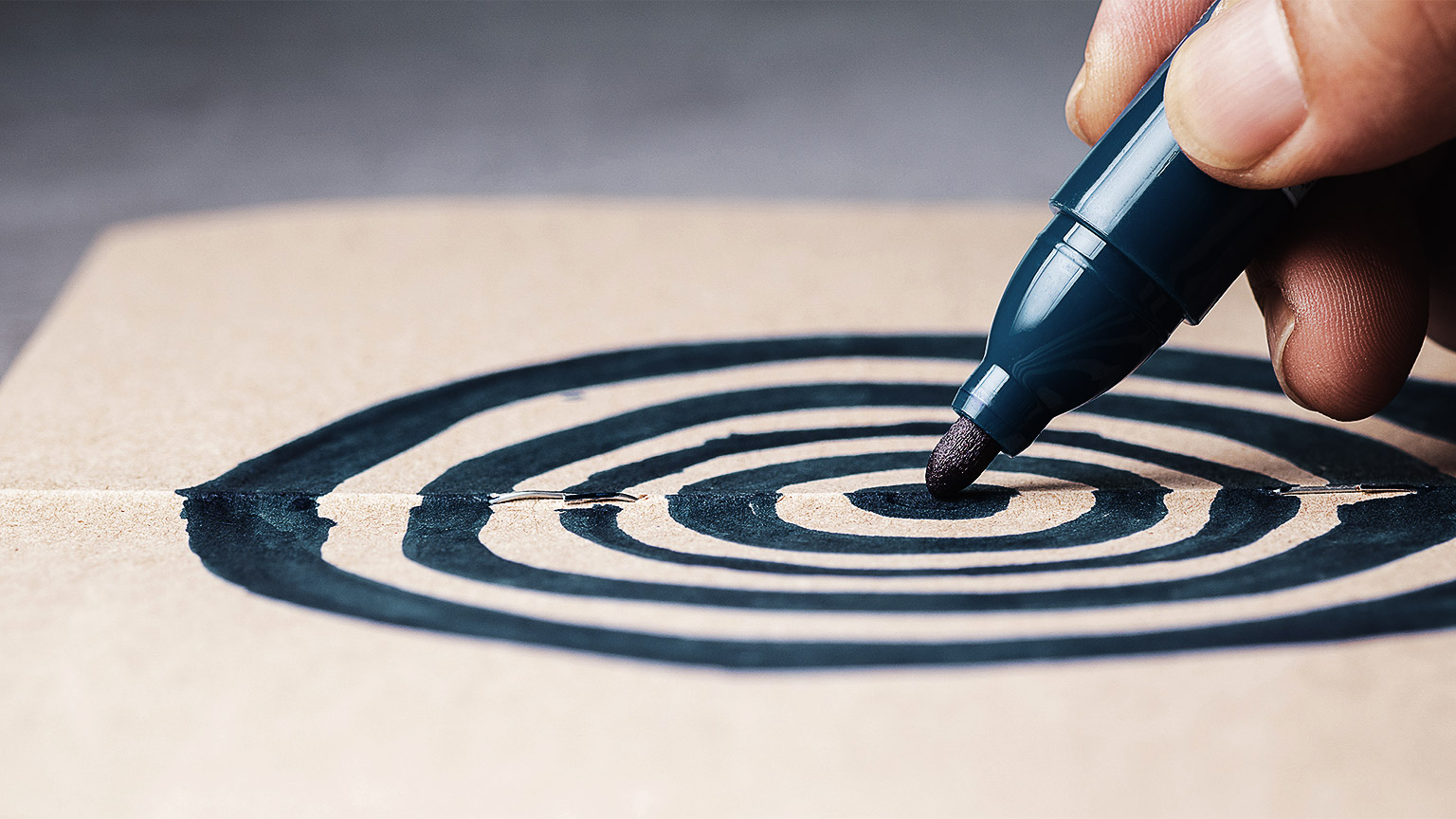 A hand drawing a target