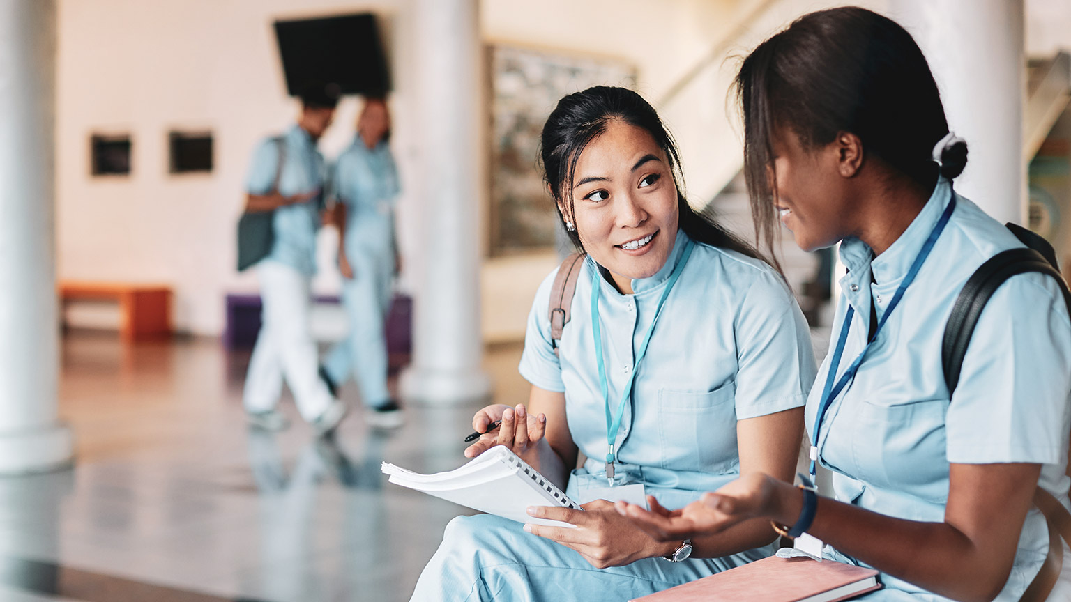 2 healthcare worker colleagues talking