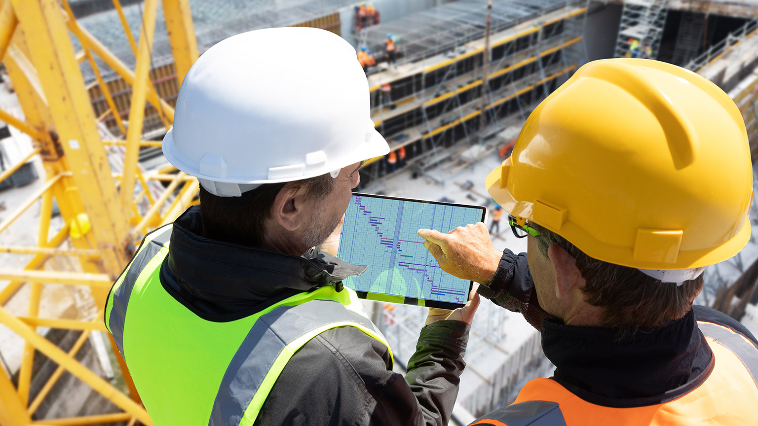 2 people looking at a gantt chart on a work site