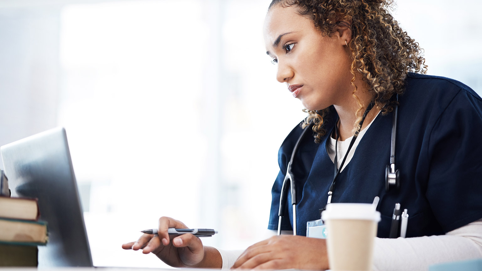 A nurse reading medical information on a laptop