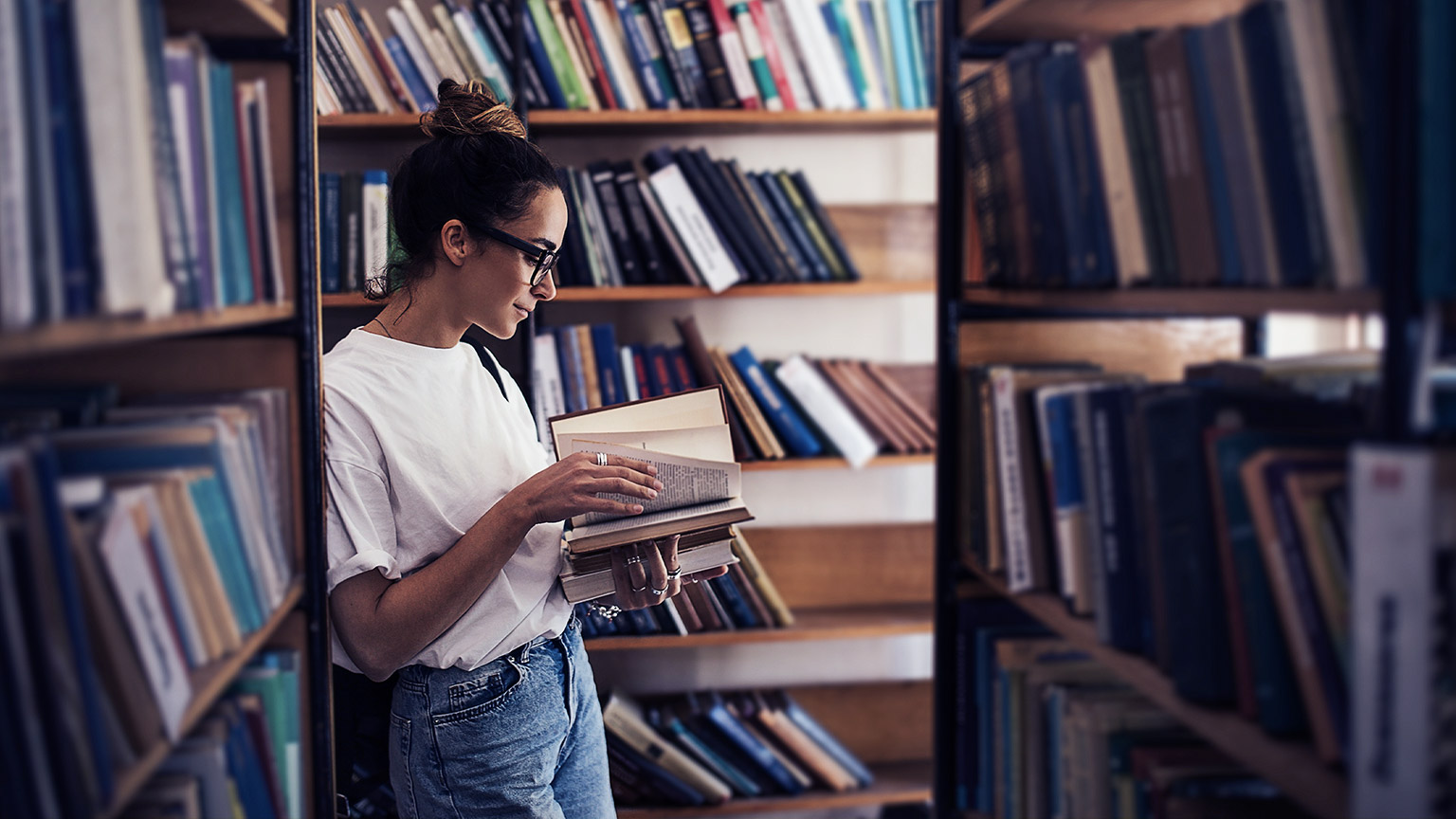 A person reading a book in a library