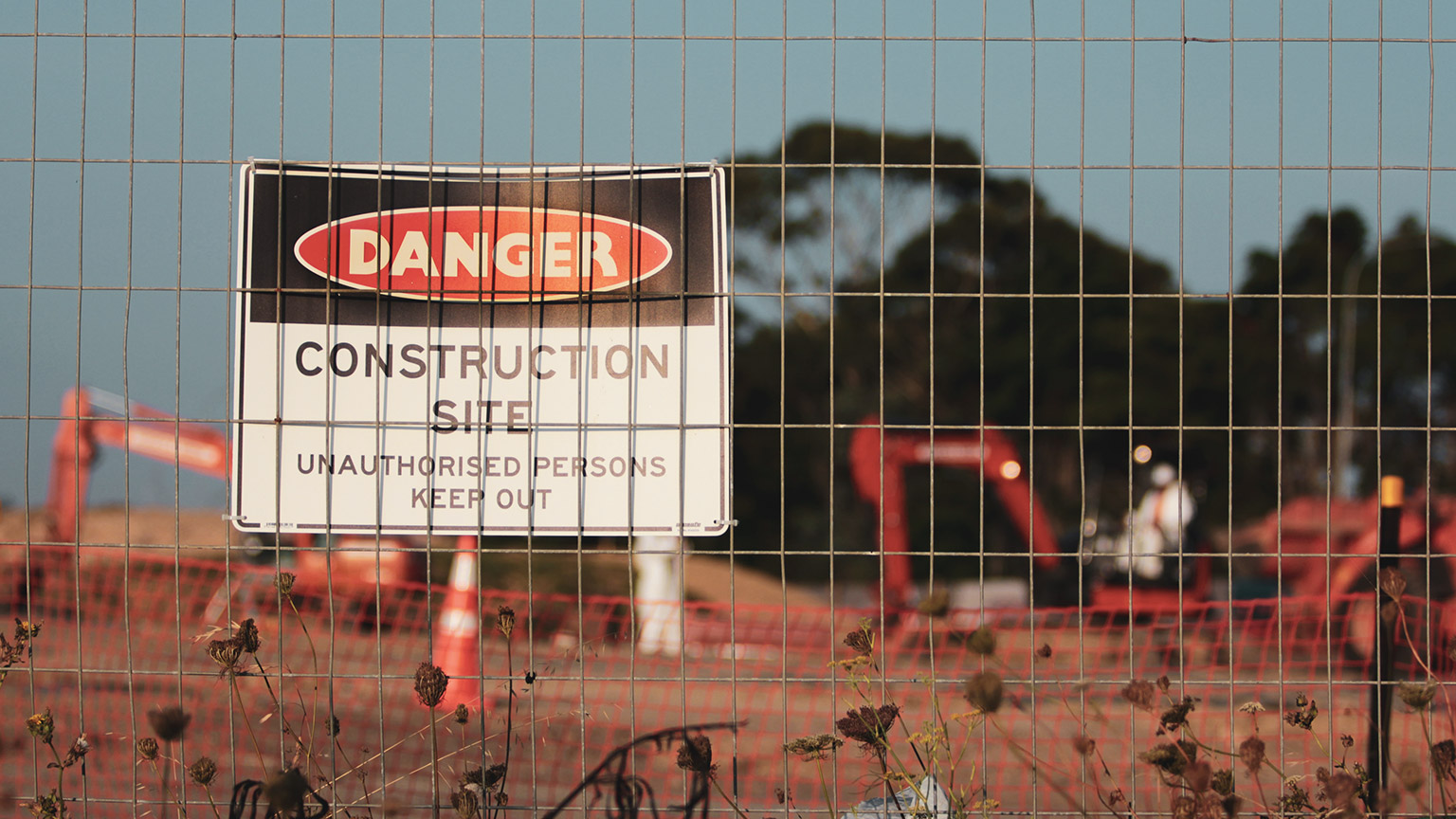 A construction site sign on a fence