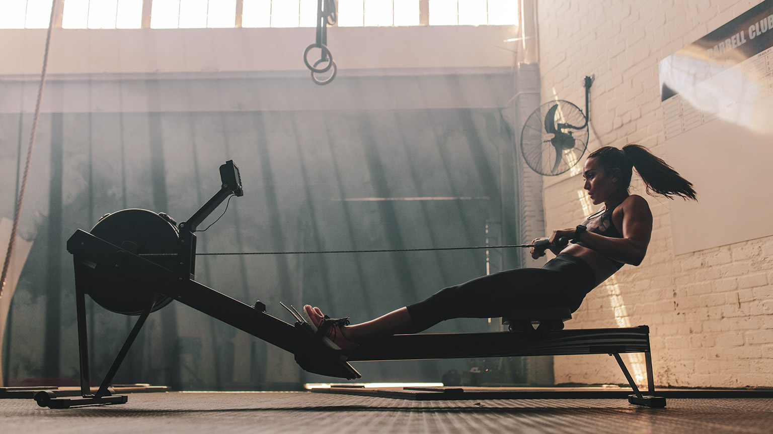 A person doing cardio on a rowing machine