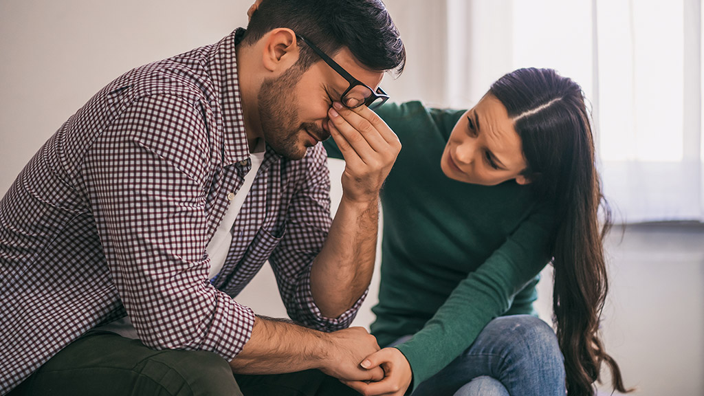  sad and depressed, and a woman is consoling him