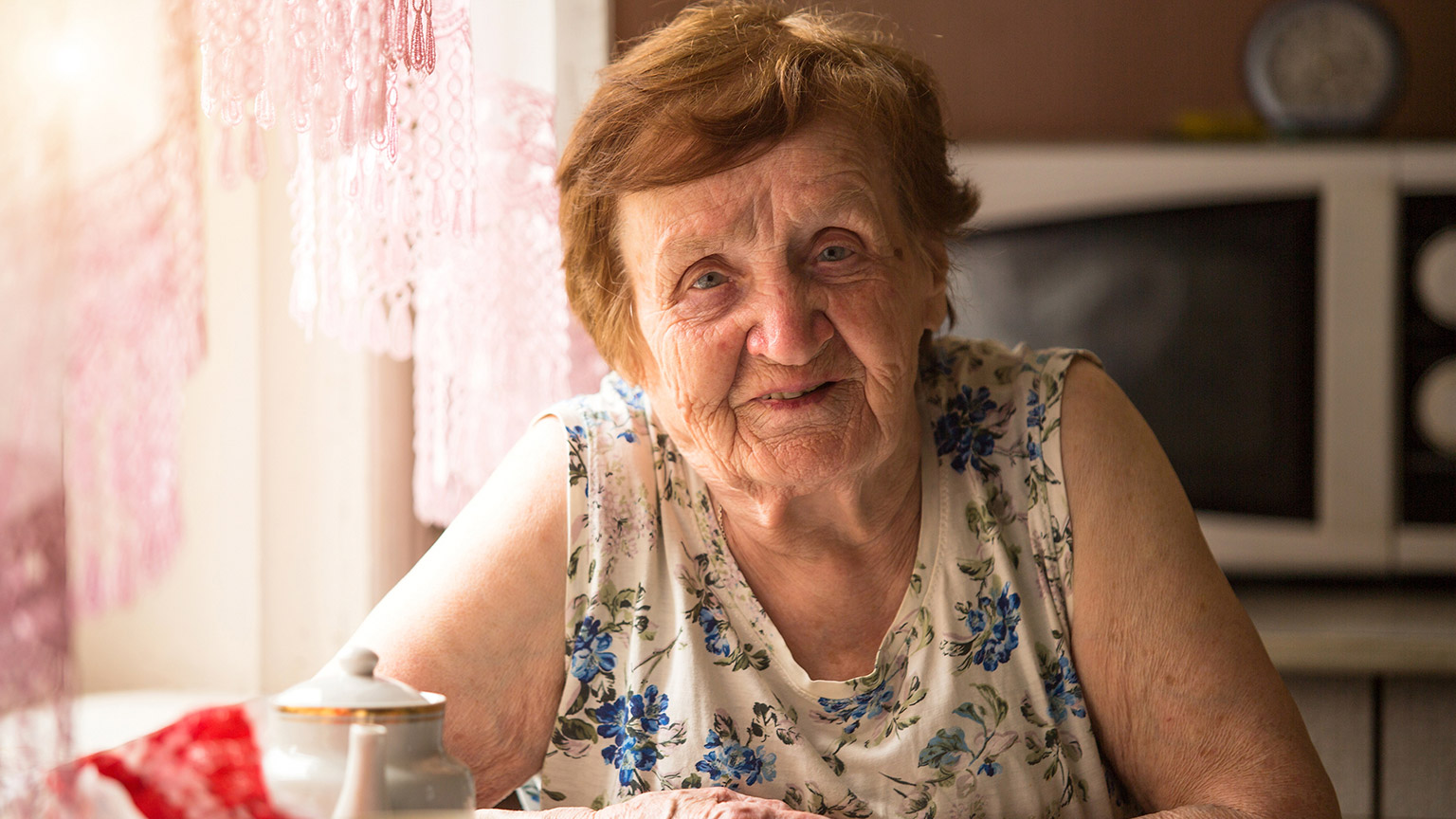 An elderly lady smiling at the camera