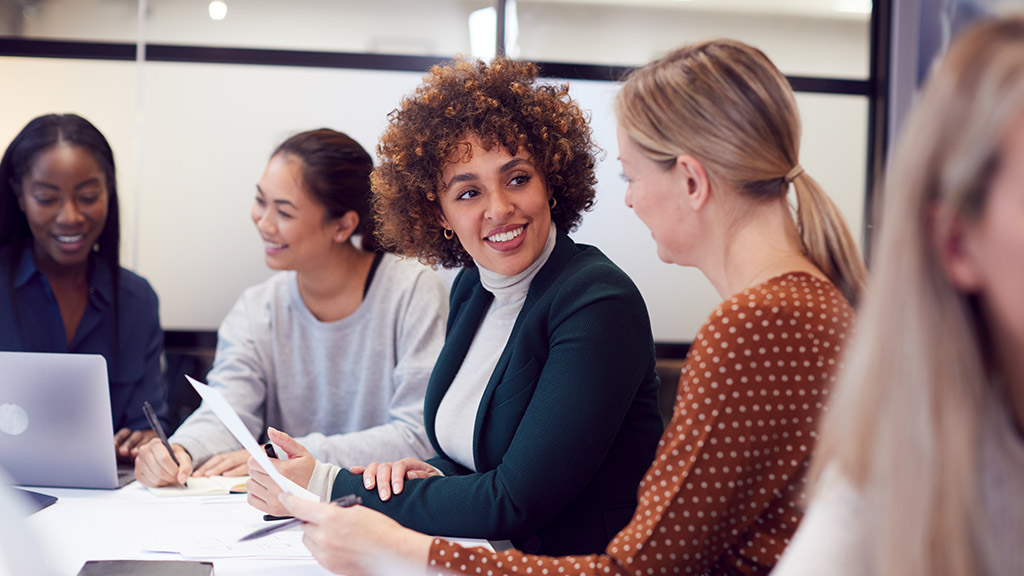 Group Of Businesswomen Collaborating In Creative Meeting Around Table In Modern Office